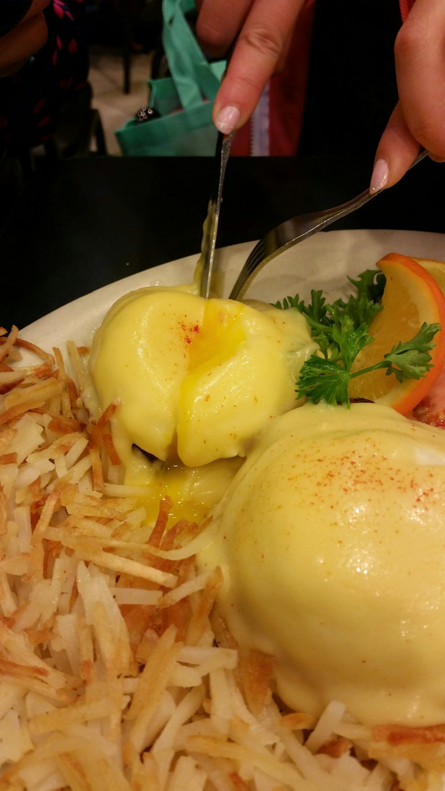 Une assiette avec des œufs pochés, des pommes de terre rissolées et du persil