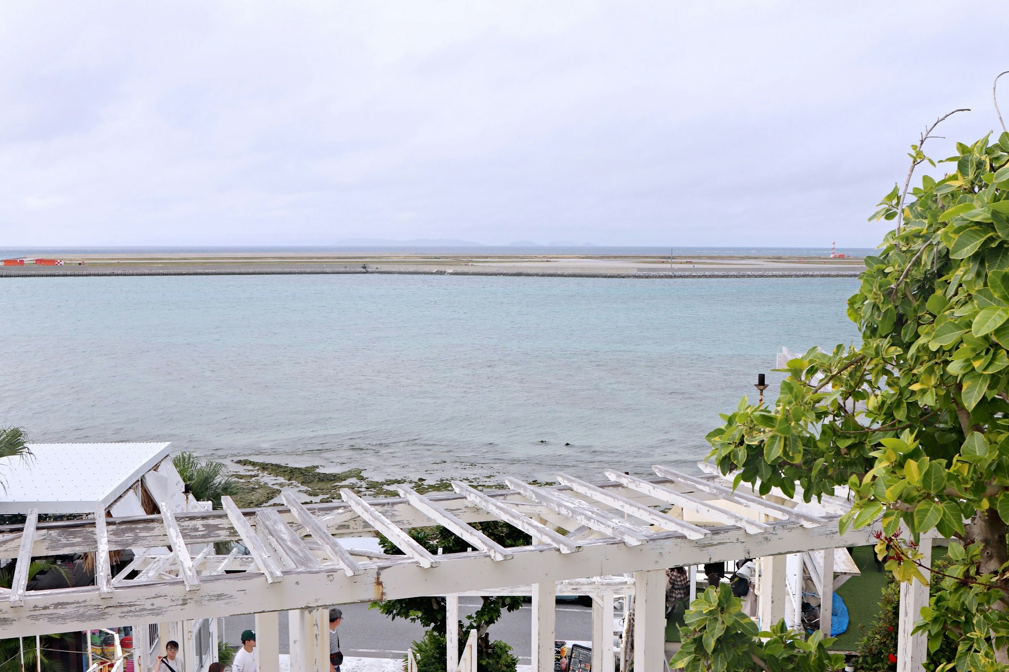 pérgola blanca junto al mar con vista al océano azul