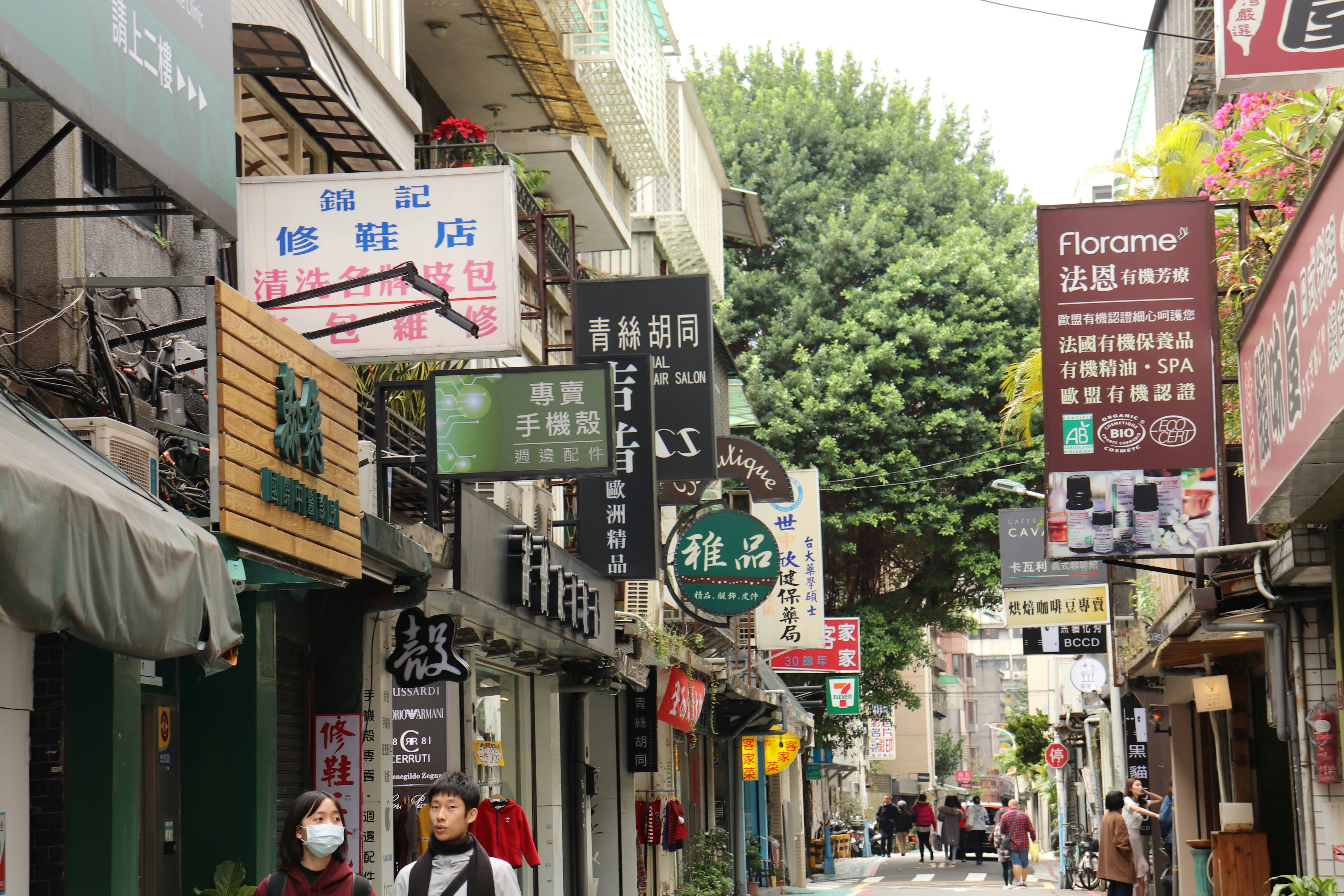shopfront signs and bicycles along a narrow shopping alley