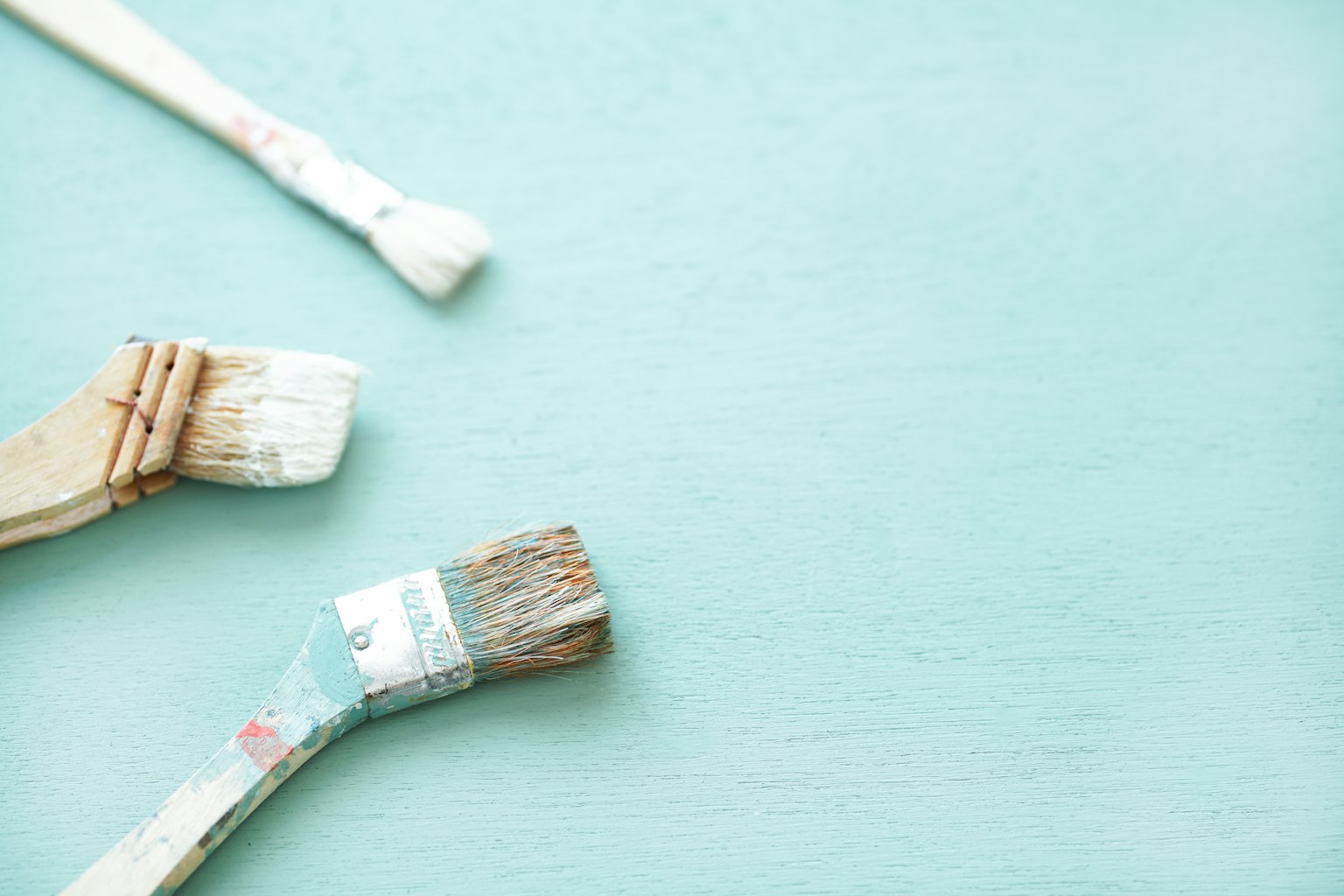 Différentes brosses à peinture sur un fond bleu