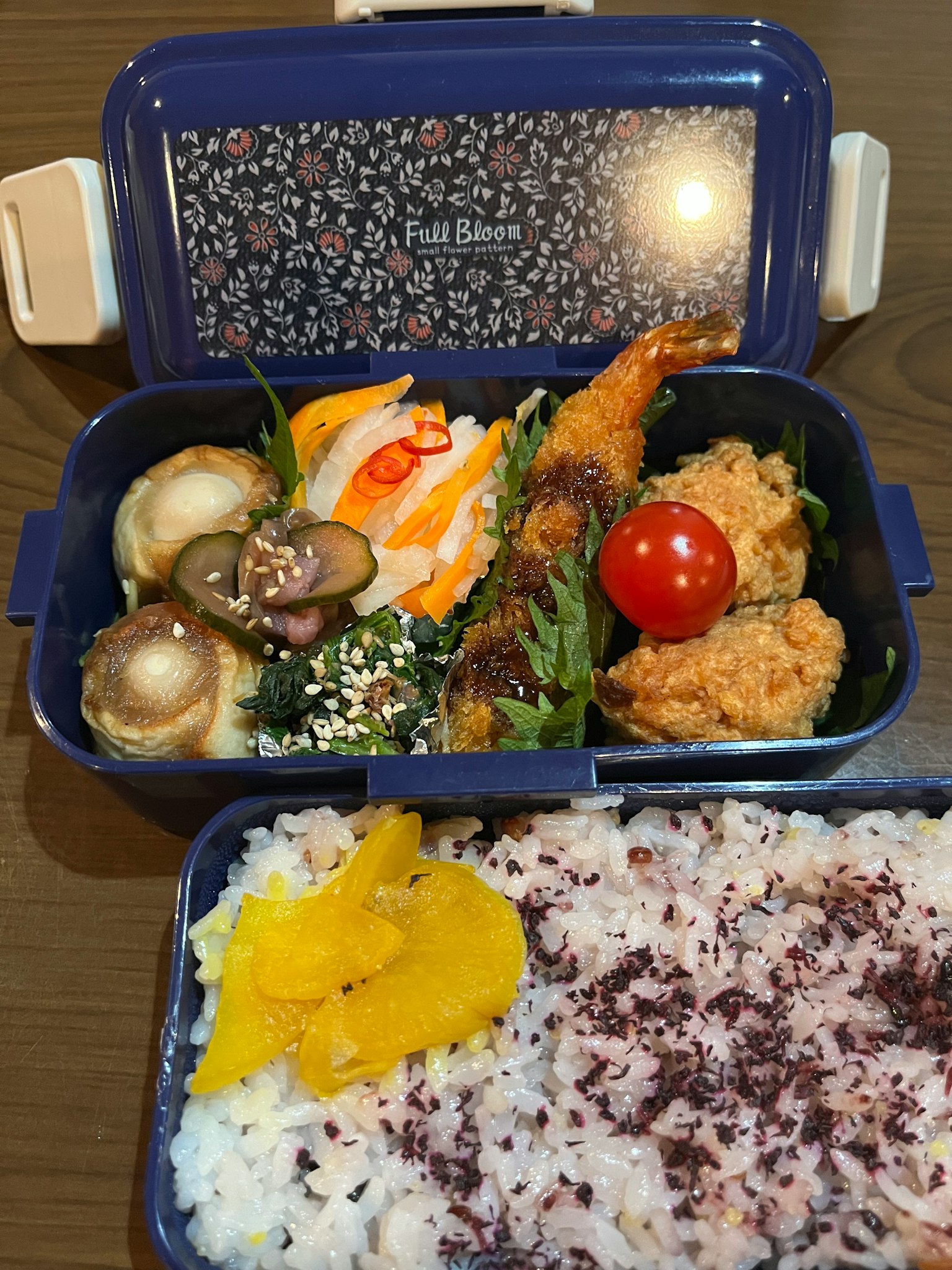 Pasto colorato in un bento blu con gamberetti fritti e pollo verdure fresche e riso