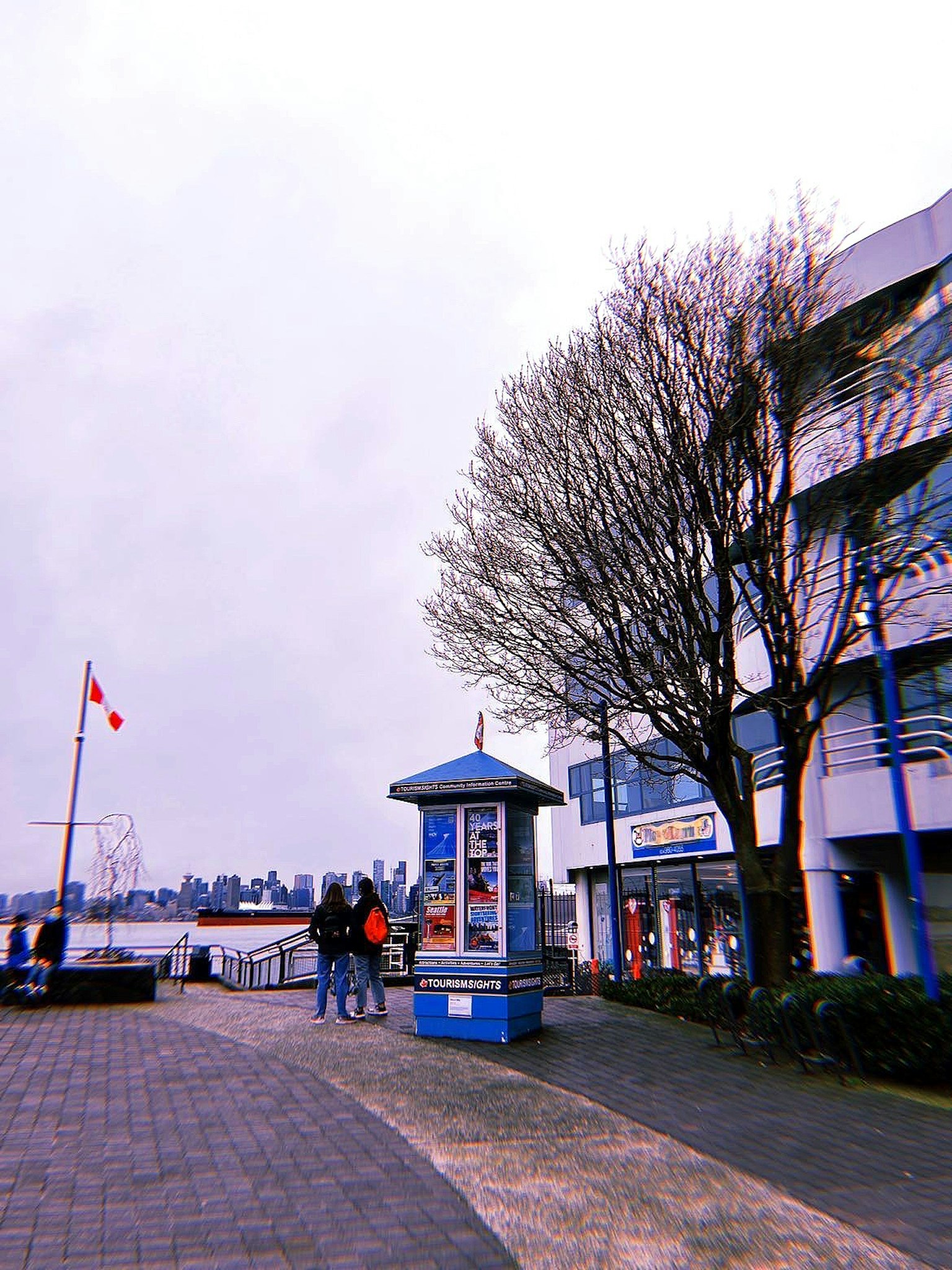 海滨步道上的人们和蓝色信息亭的场景