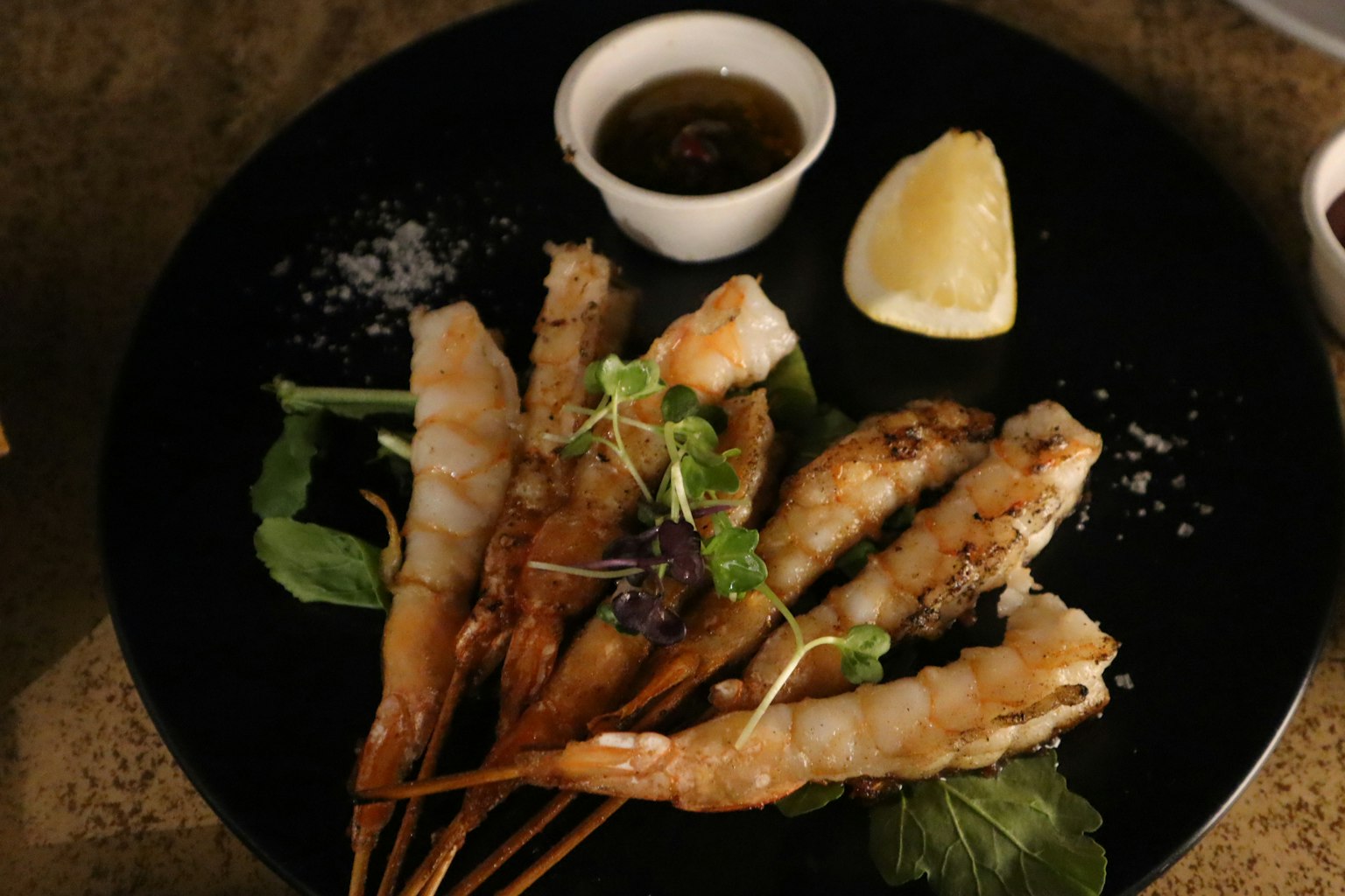 Un plat de crevettes joliment présenté avec une tranche de citron
