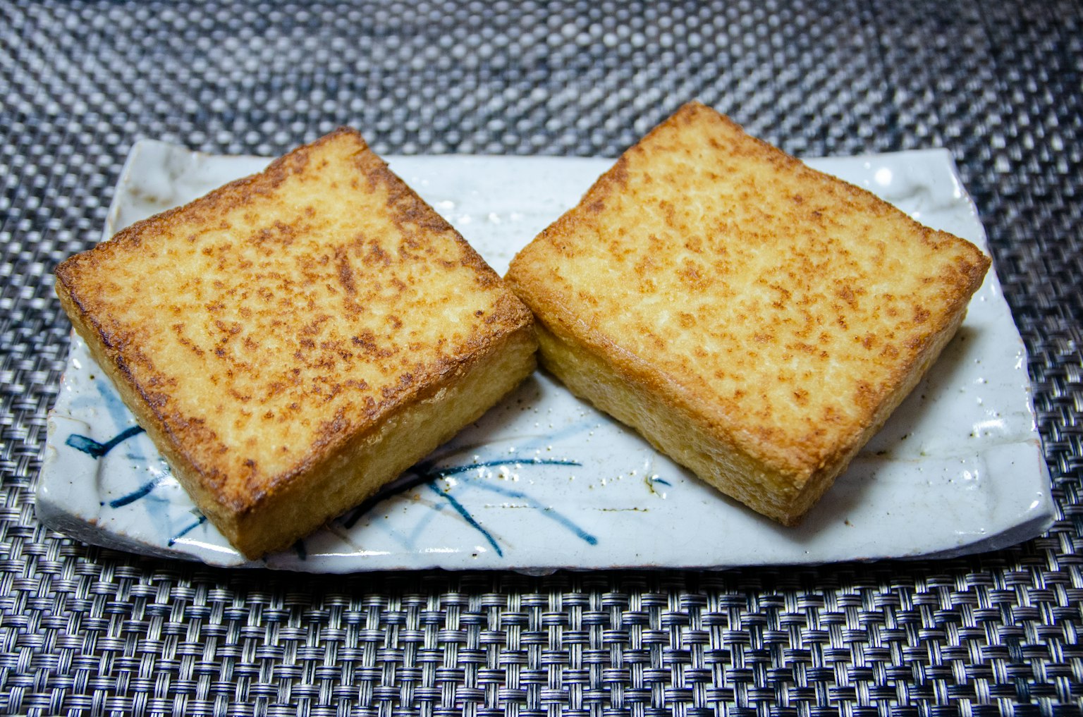 兩個表面呈棕色的方形烘焙食品放在白色盤子上