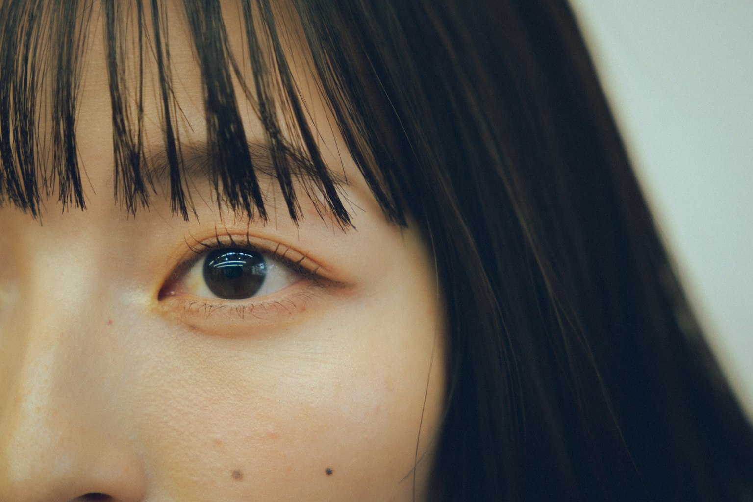 Acercamiento del ojo de una mujer con pestañas delicadas y textura de piel natural