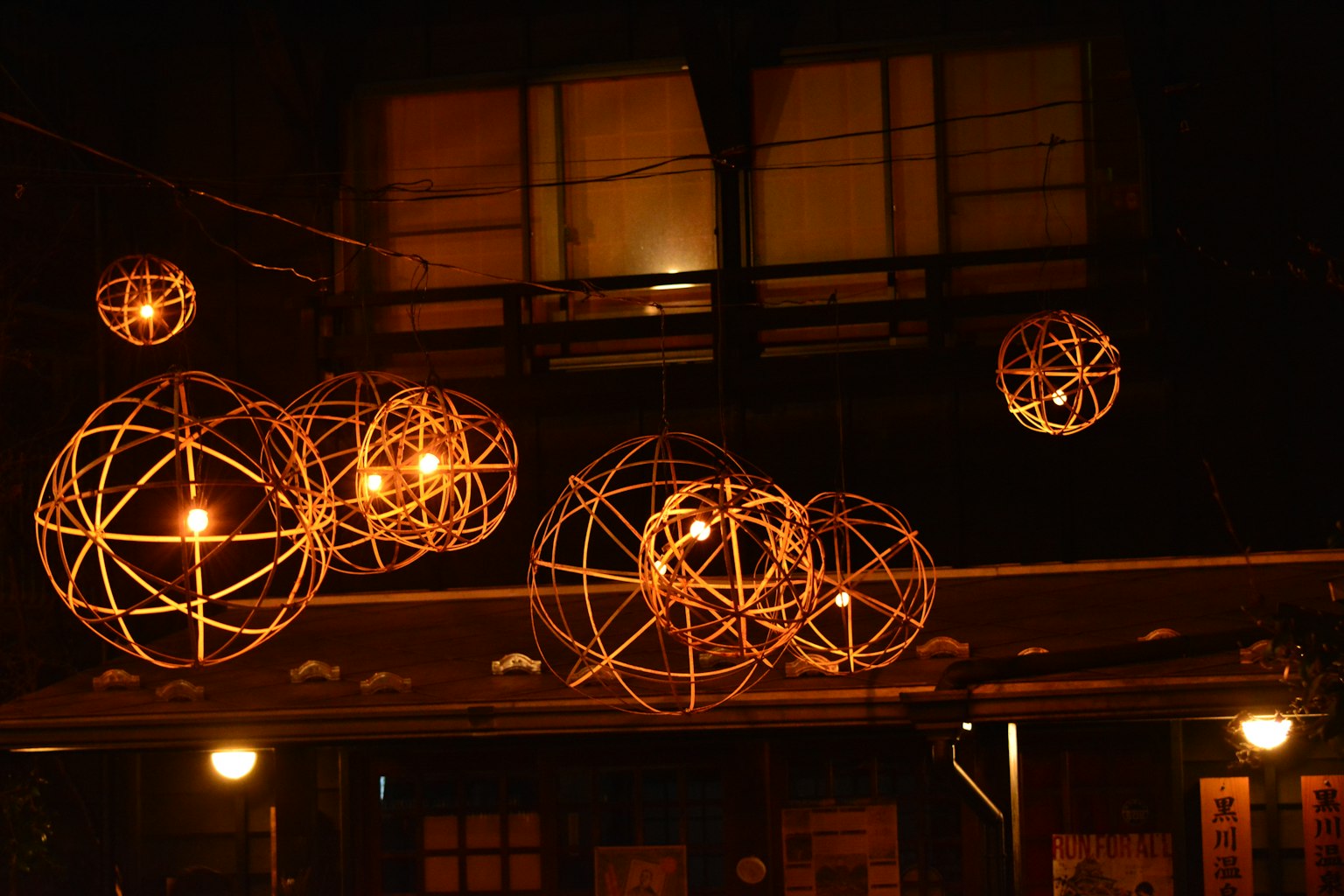 Lampade sferiche in bambù appese che brillano di notte