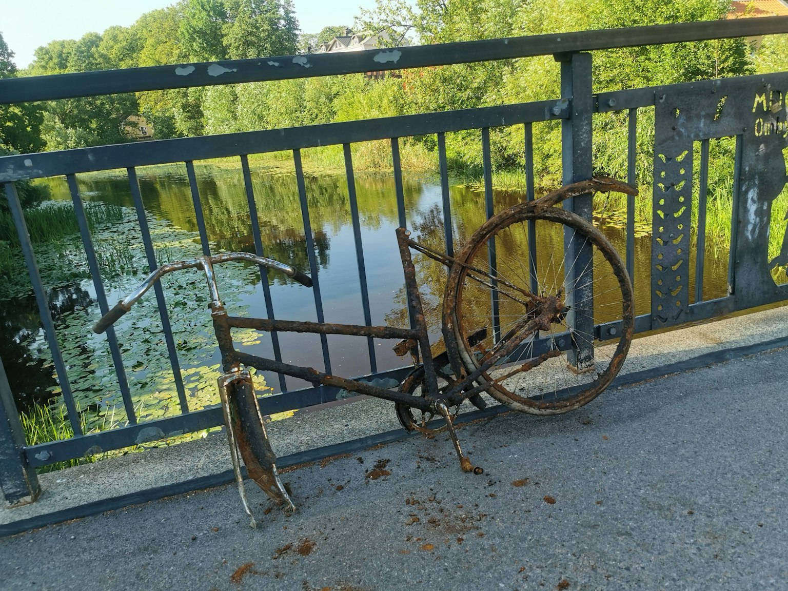 Bicyclette rouillée reposant sur un pont surplombant une rivière