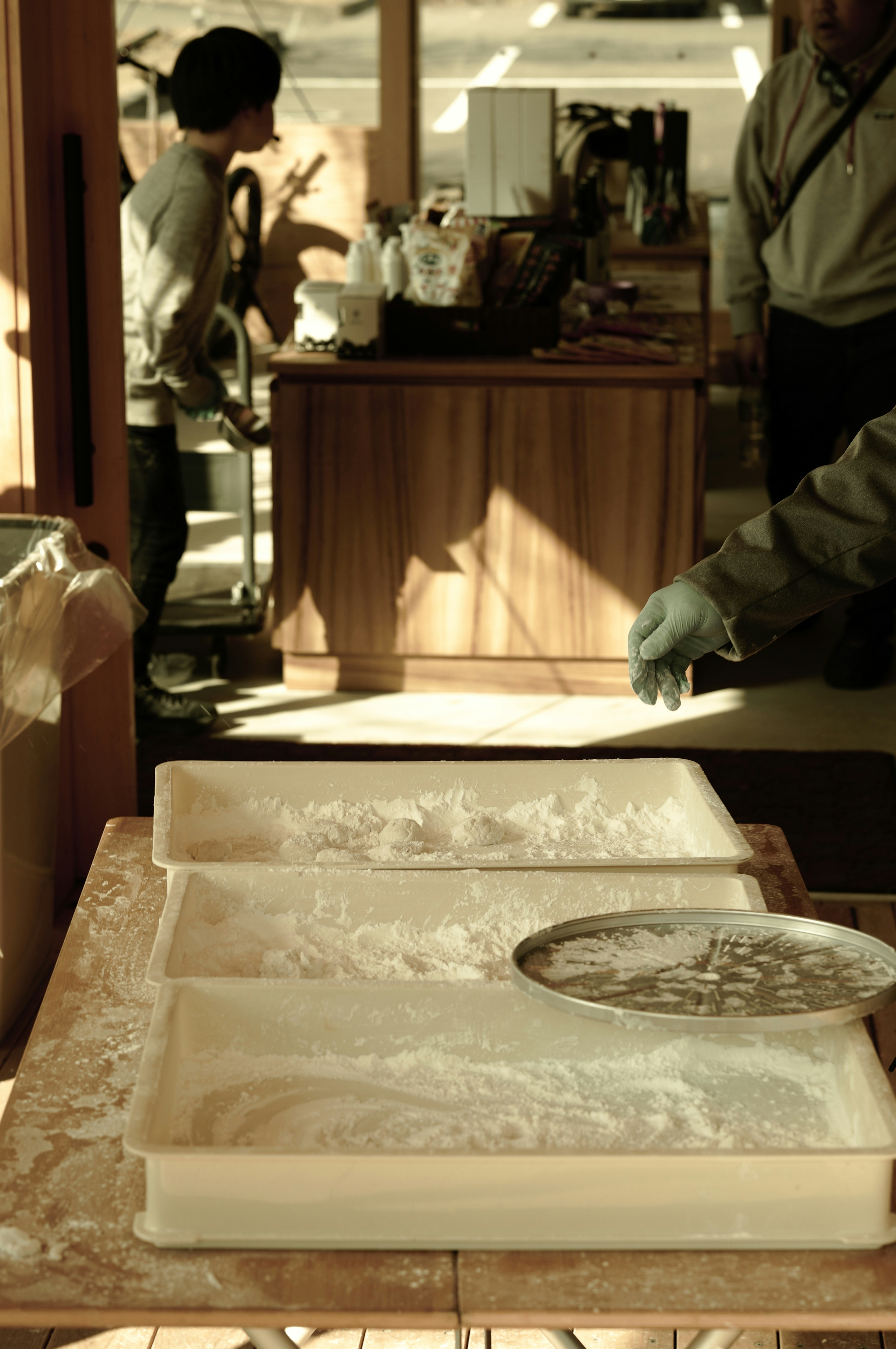 餅を作る店内の作業台で粉をのばす手