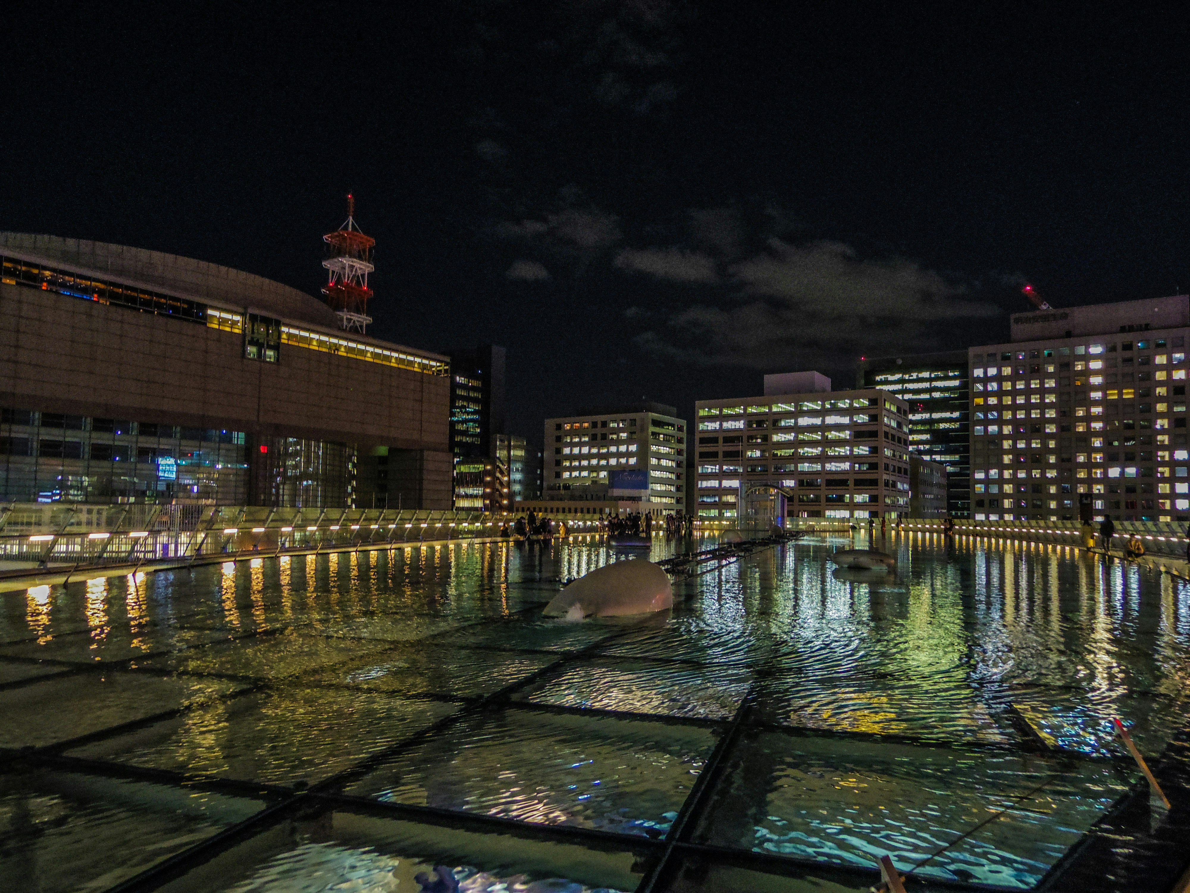 夜のオアシス21の水辺とライトアップされた建物群