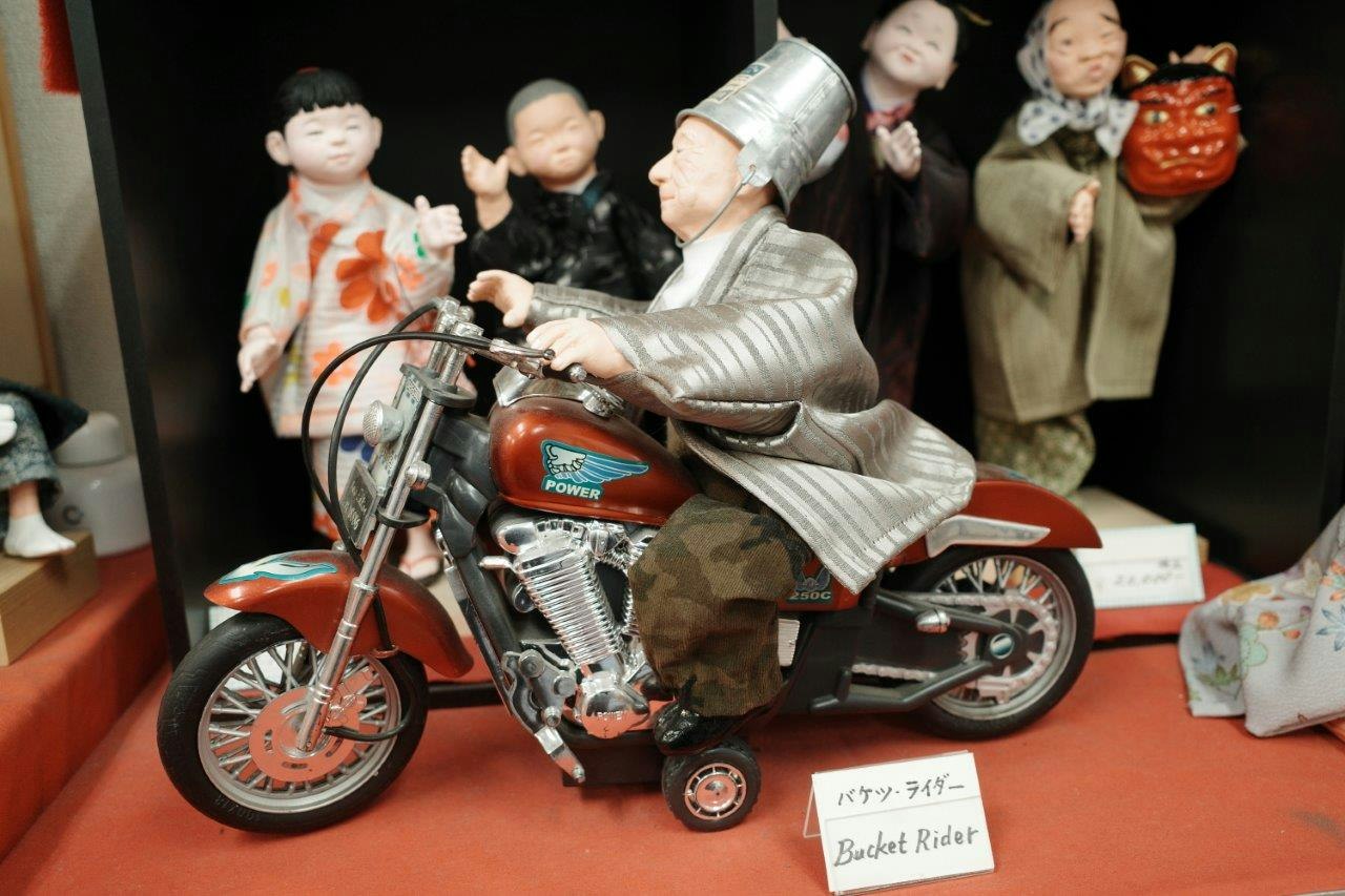 primer plano de una vitrina de exhibición con un modelo de motocicleta y muñecos