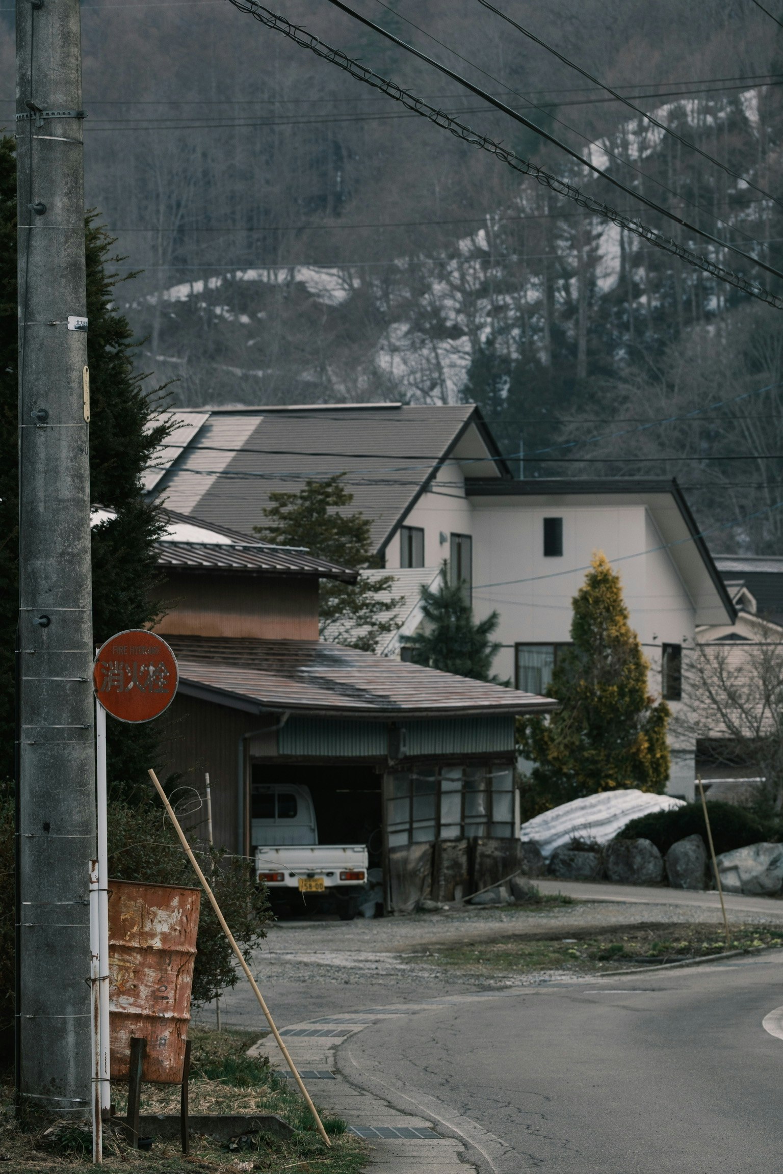Quiet village scene in the mountains featuring old and new houses alongside a winding road and utility poles