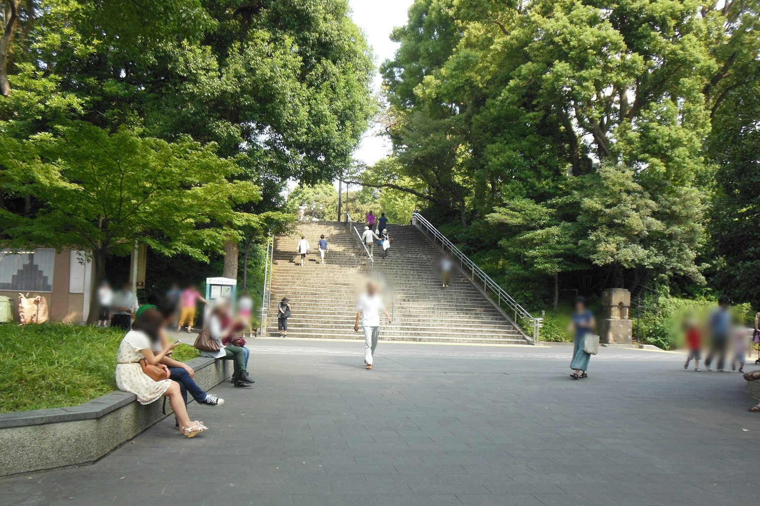 Parkszene mit Treppen und Bäumen mit sitzenden Menschen