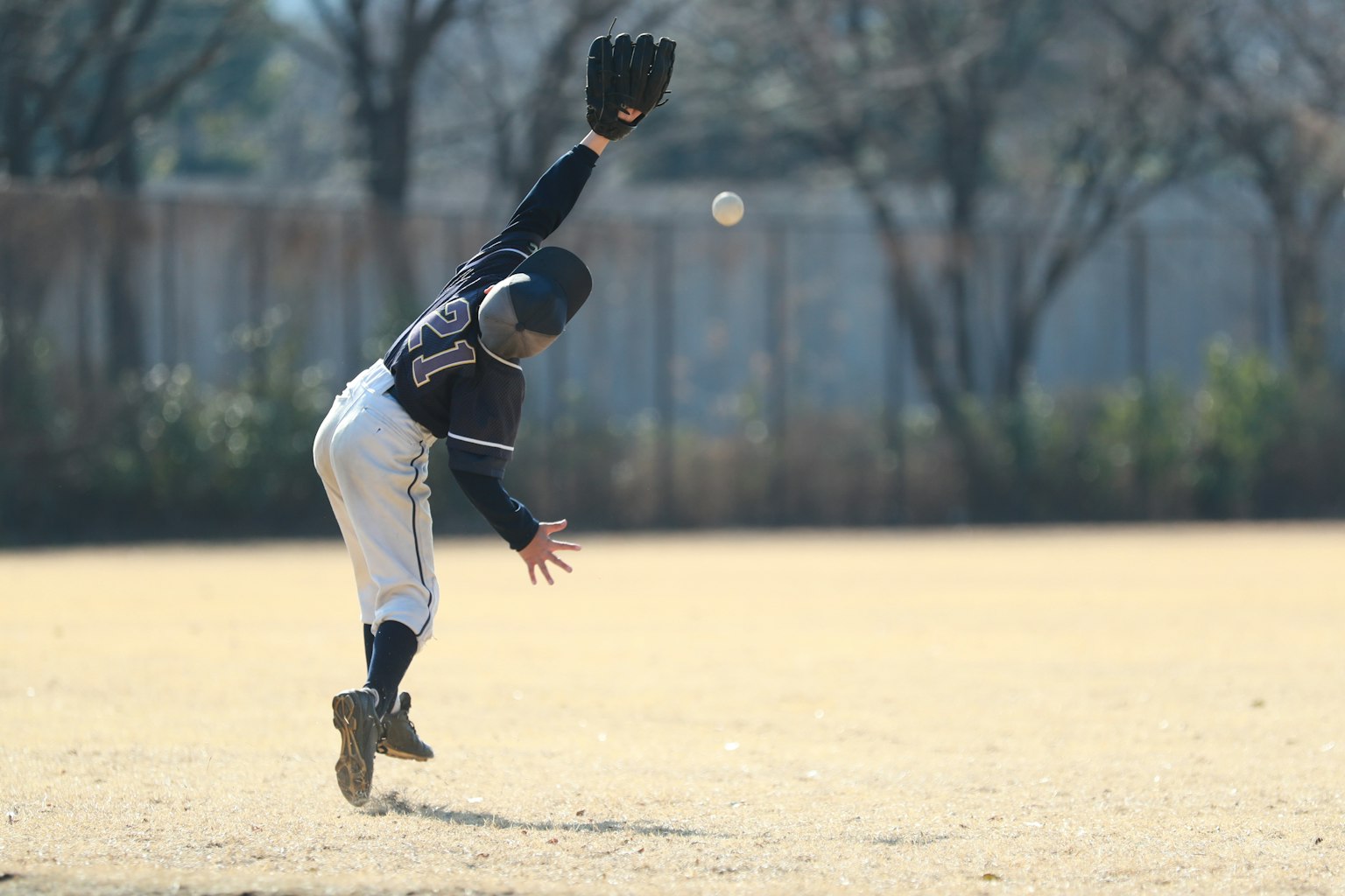 Giocatore di baseball che cerca di prendere una palla con un guanto