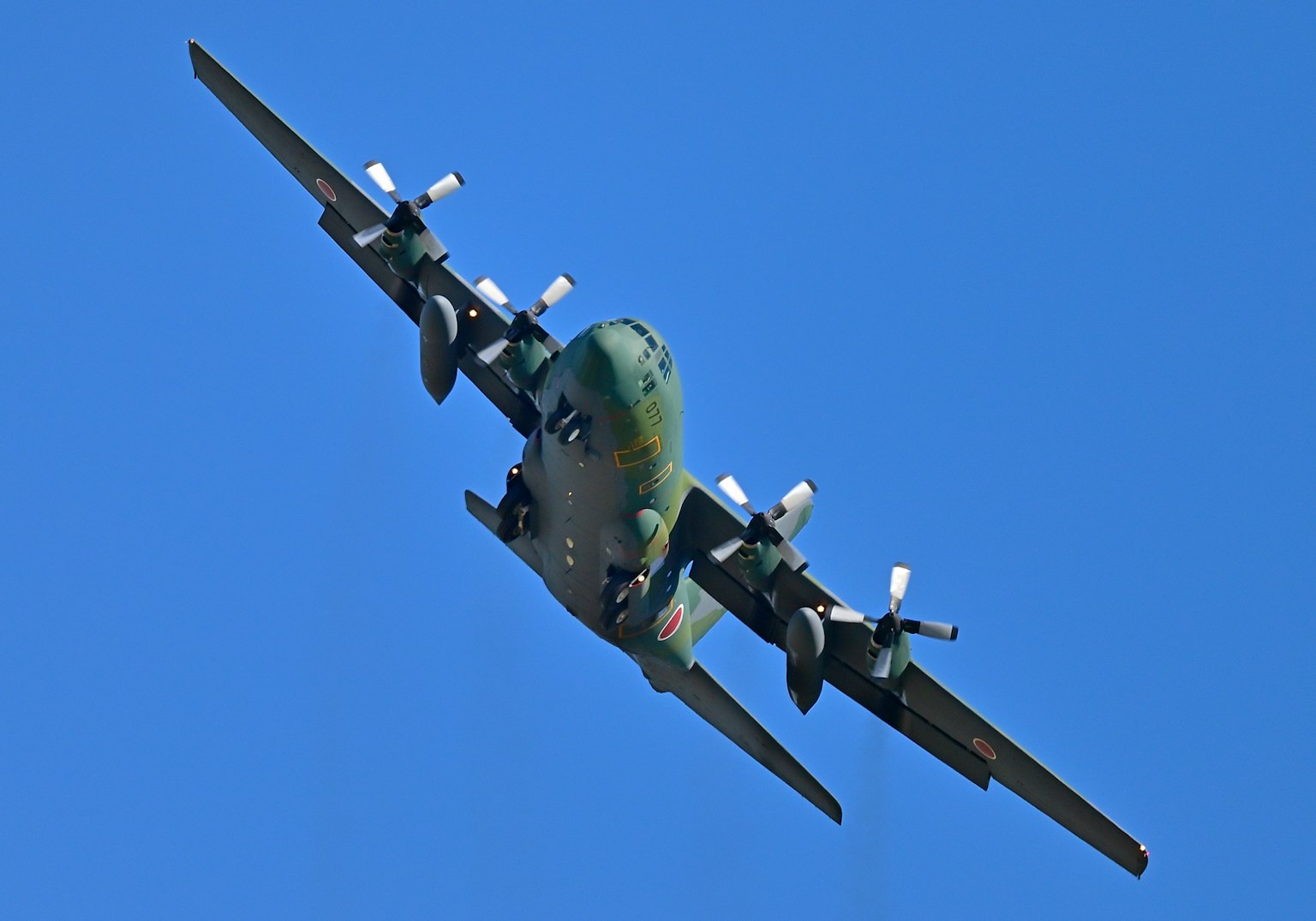 Military transport aircraft flying against a blue sky