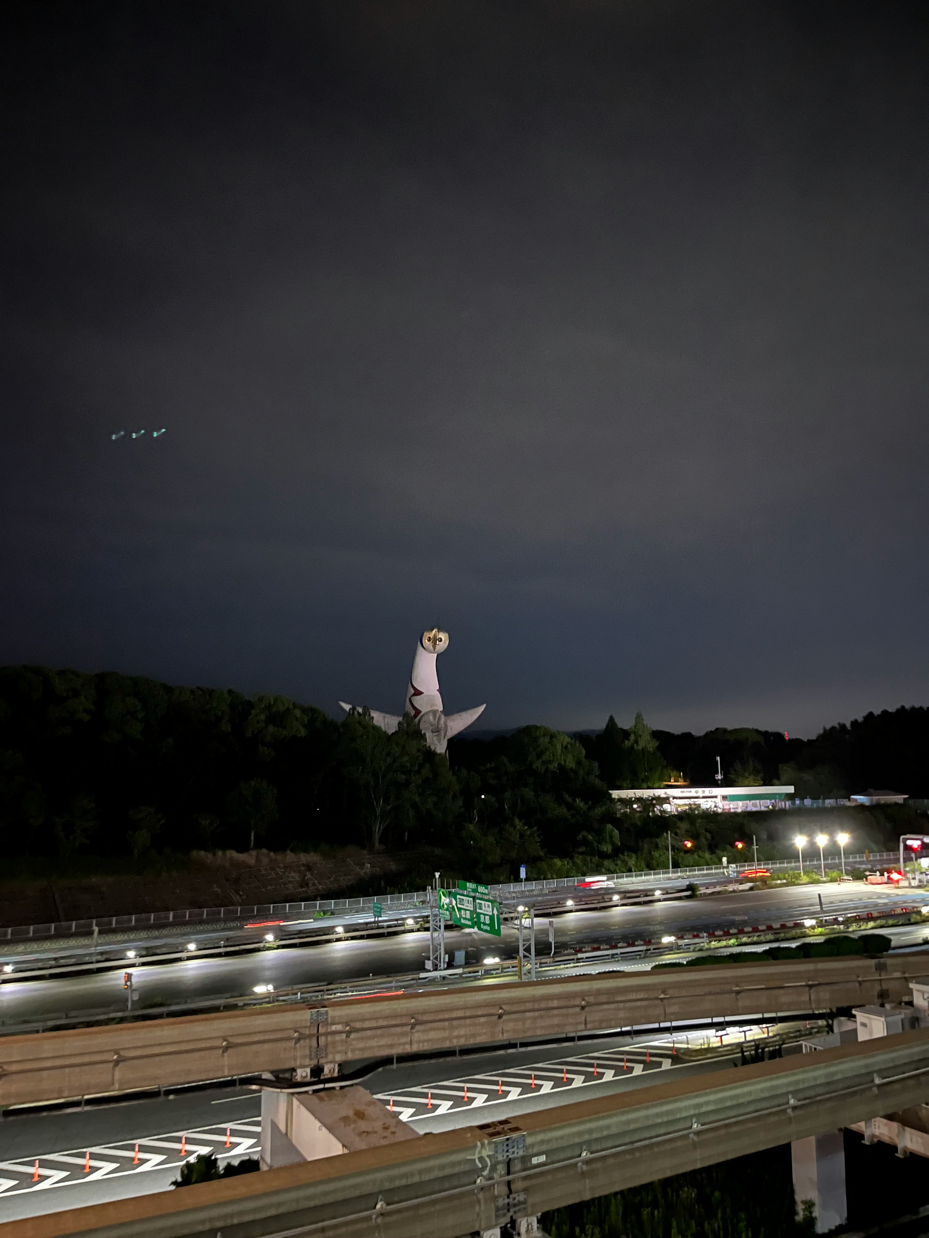 夜の高速道路と高架の上を歩く人物