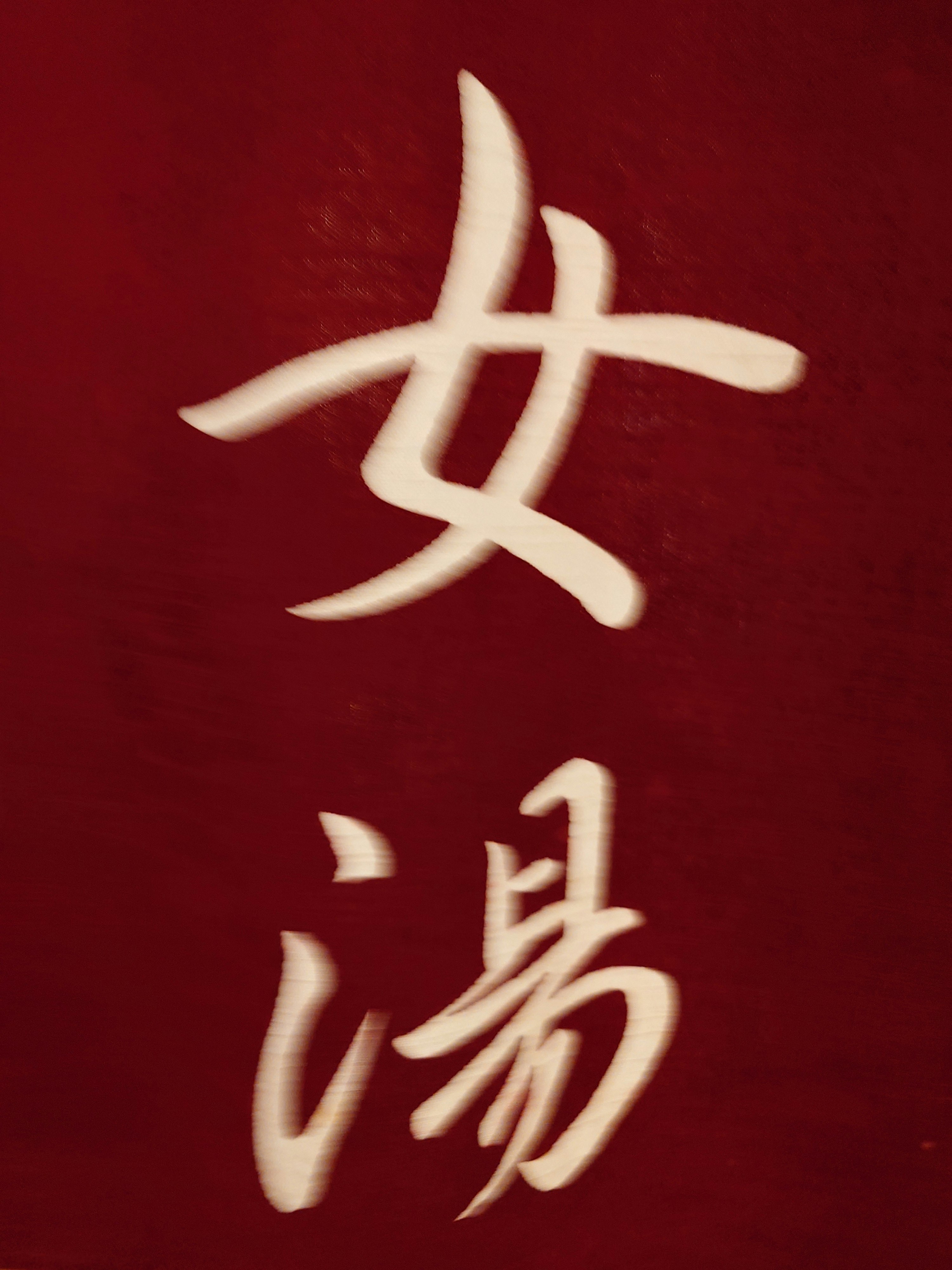 caracteres chinos dorados “女郎” sobre fondo rojo