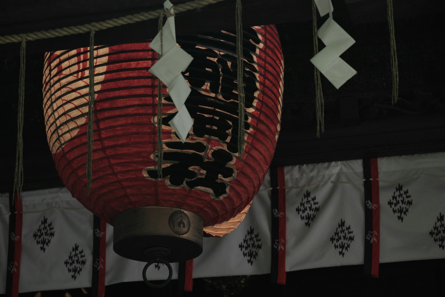 Đèn lồng đỏ với ký tự Nhật Bản tại lối vào đền thờ