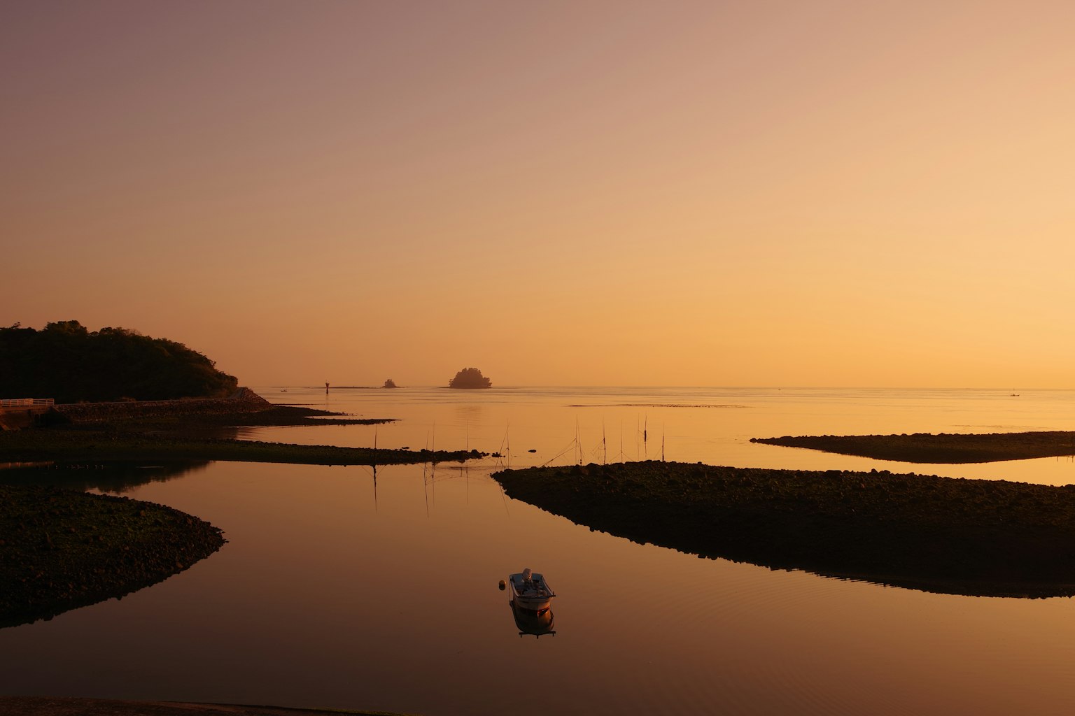 Costa serena al atardecer con reflejos de agua tranquilos