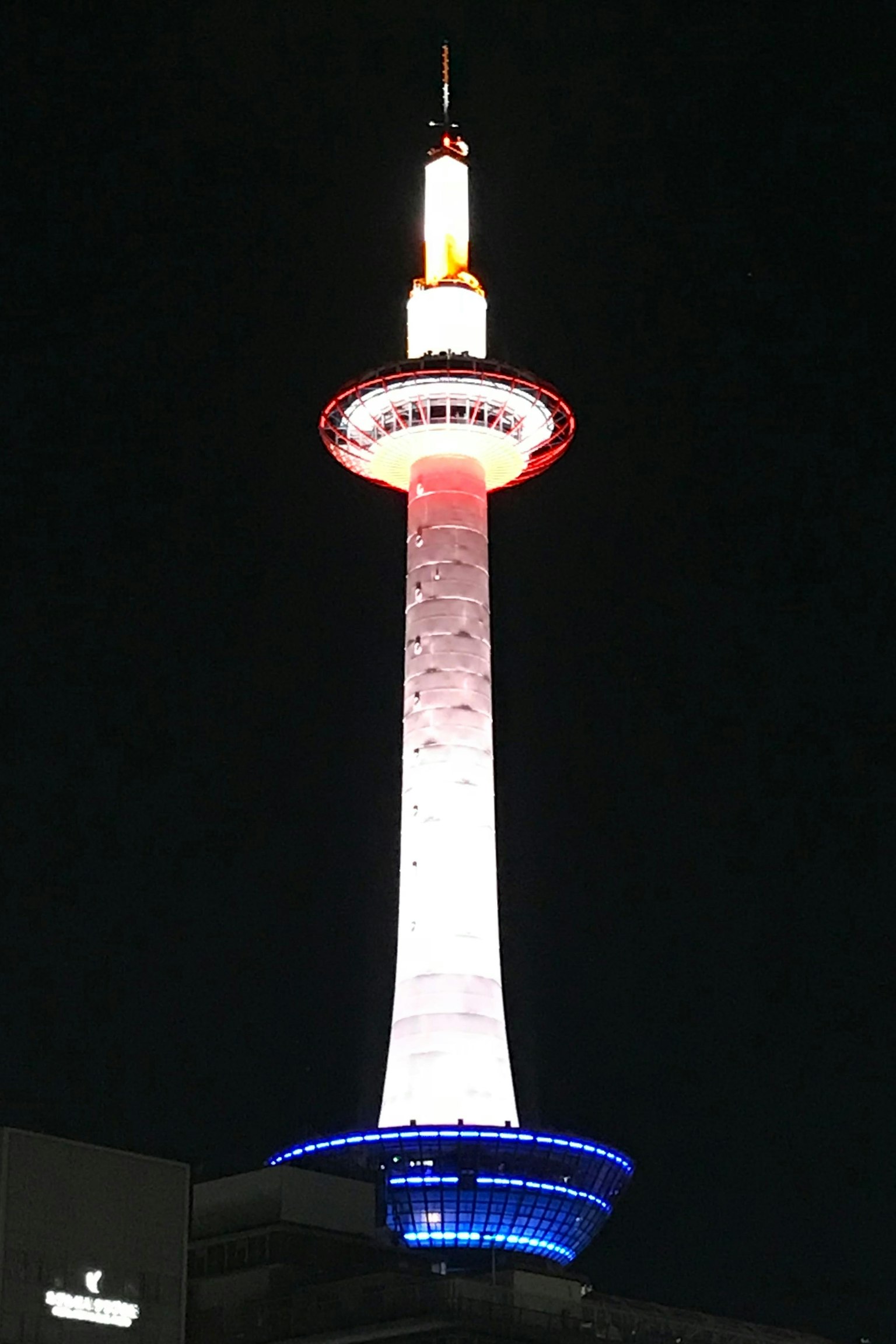 Menara Kyoto diterangi lampu merah dan biru di malam hari
