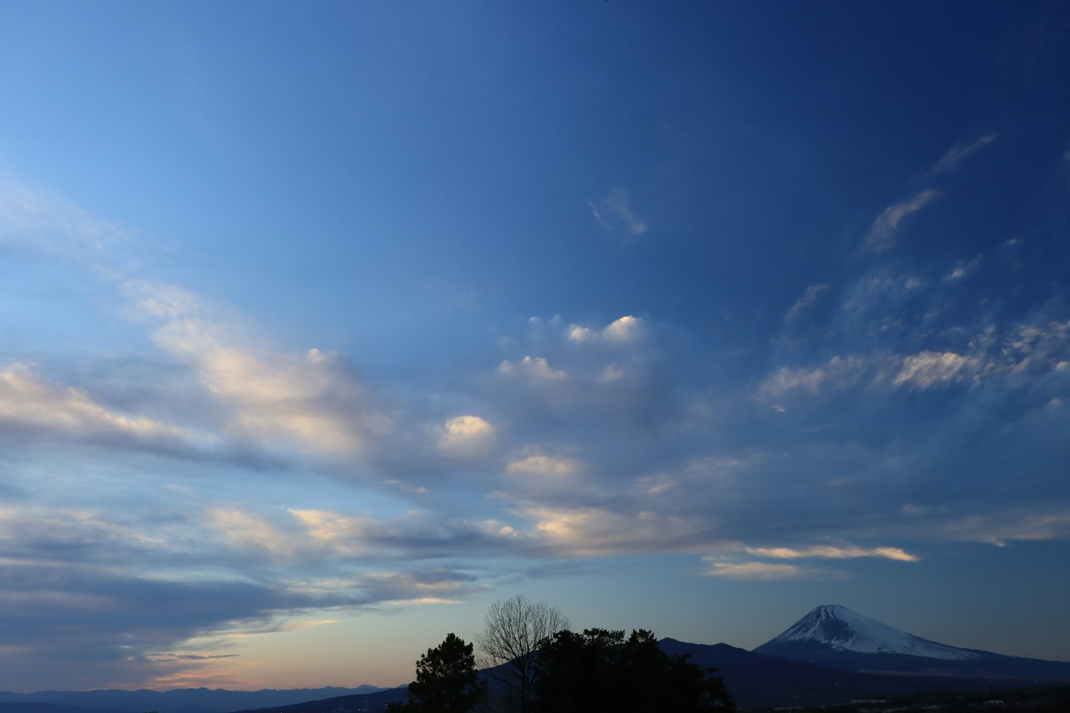 Blue sky with clouds and a distant mountain