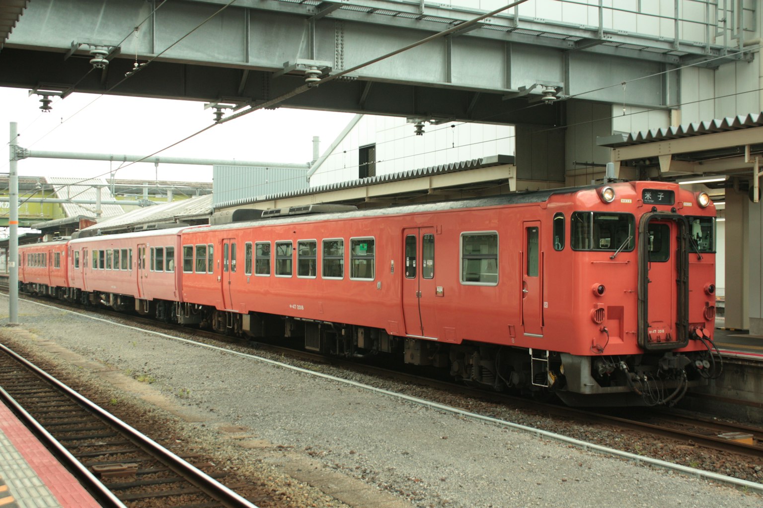 Sebuah kereta merah diparkir di stasiun