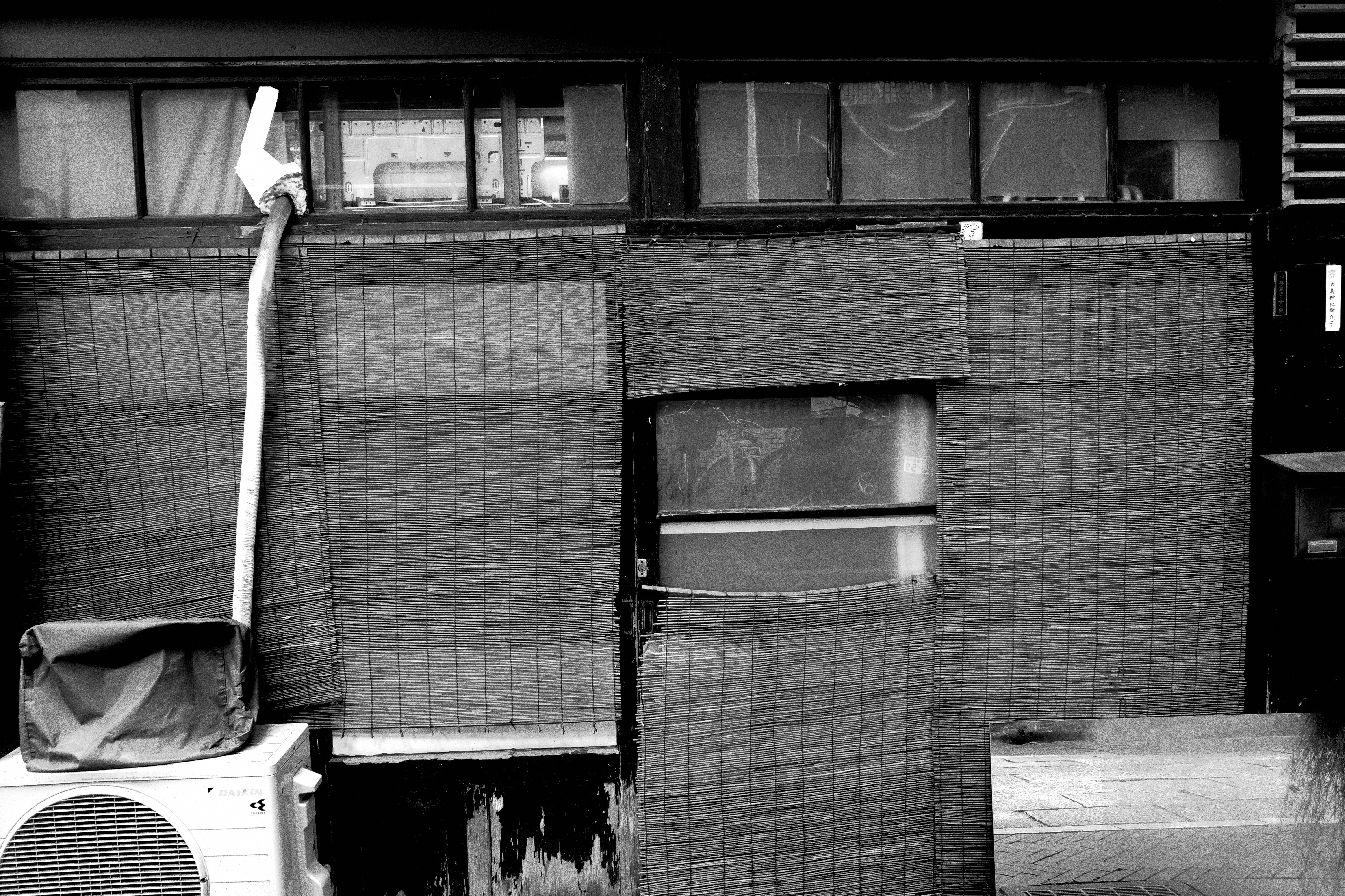 mur d’une ruelle avec cartons empilés et objets de rangement