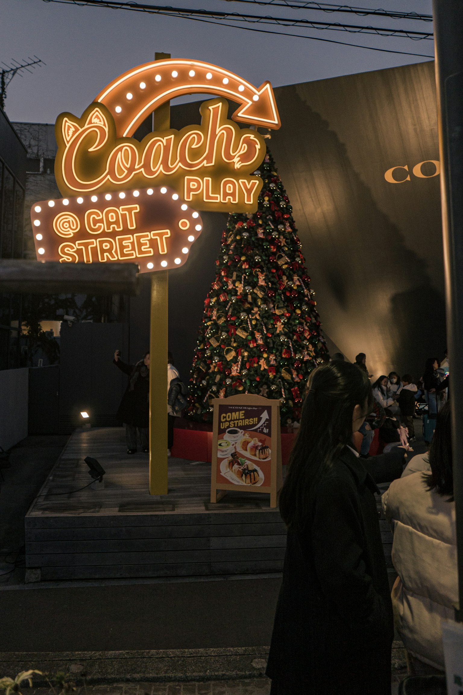 Bright Coach sign with colorful Christmas tree at Cat Street