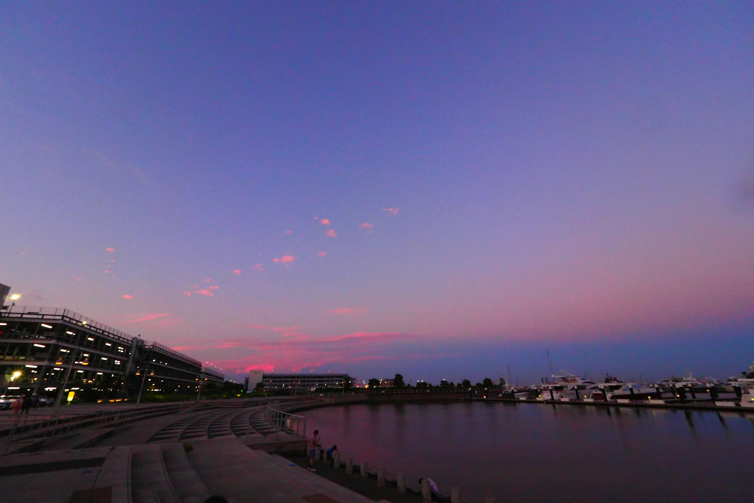 Vista escénica de un puerto al atardecer con cielo colorido y agua tranquila