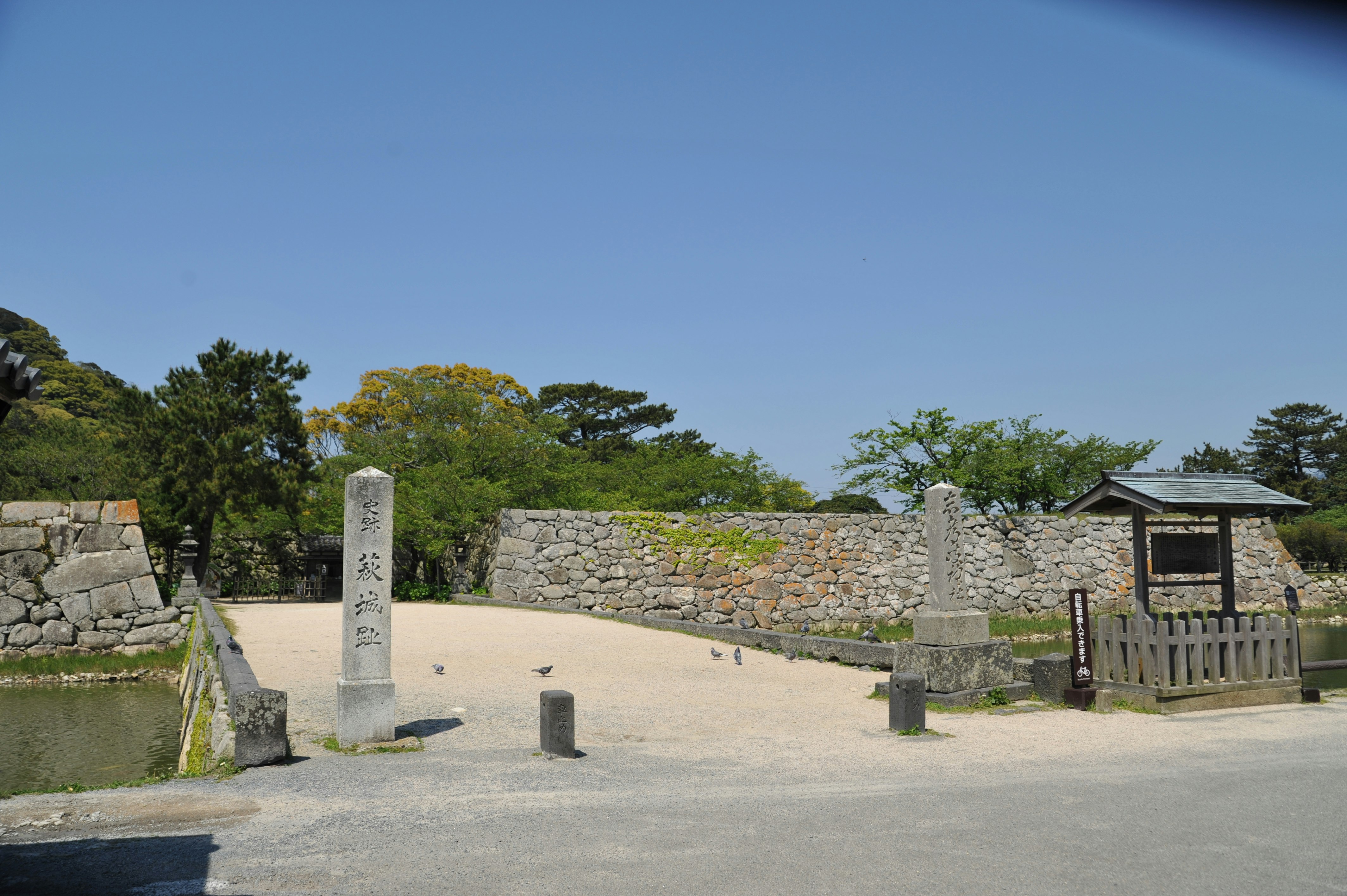 石垣と白砂の中庭、井戸のような石碑が並ぶ