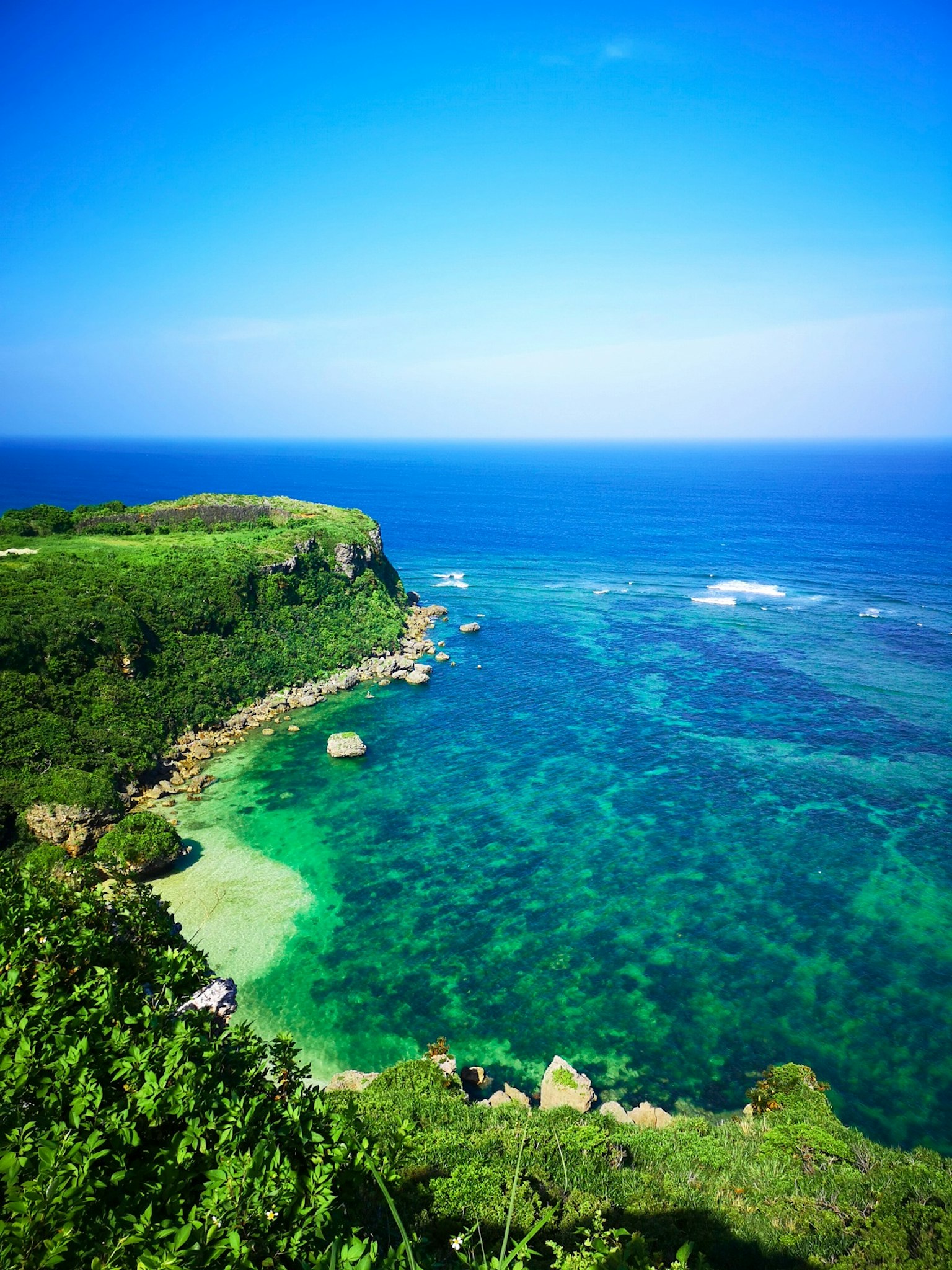 Pemandangan laut biru dan tebing hijau yang indah