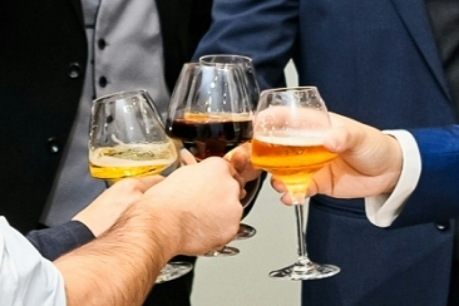 Manos de personas brindando con cuatro copas diferentes