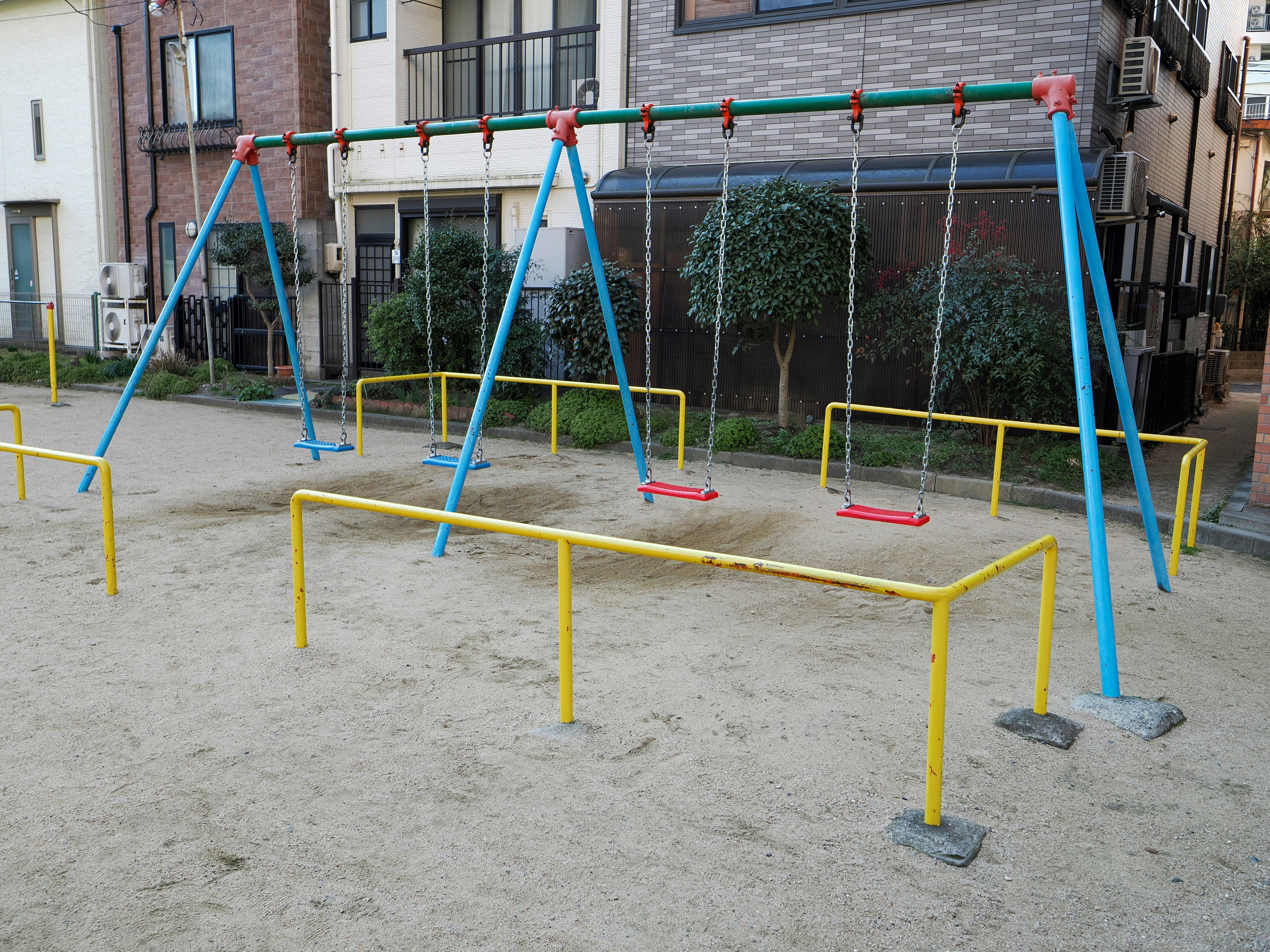 住宅街の遊具が並ぶ屋外の遊び場