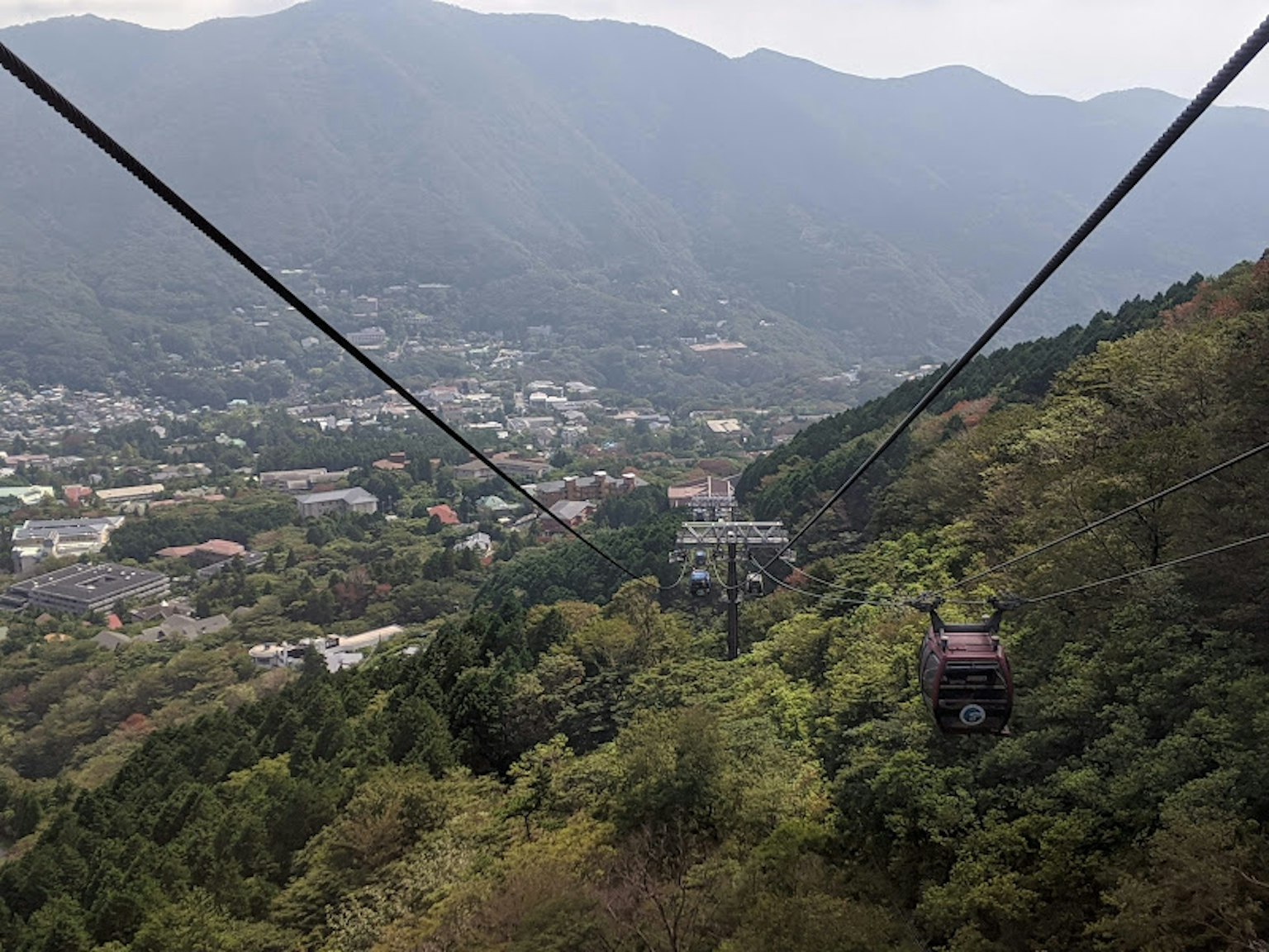 Scenic view of a cable car amidst mountains and lush greenery