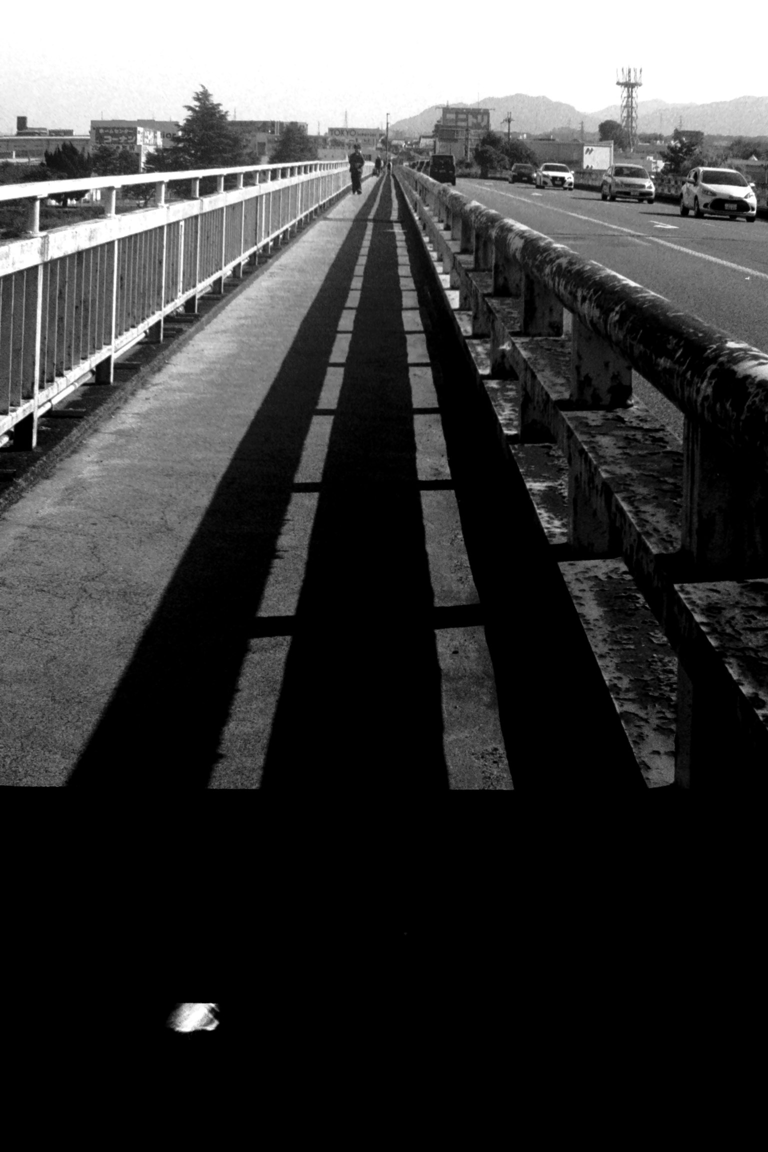 Vue en noir et blanc d'un trottoir et d'une route de pont