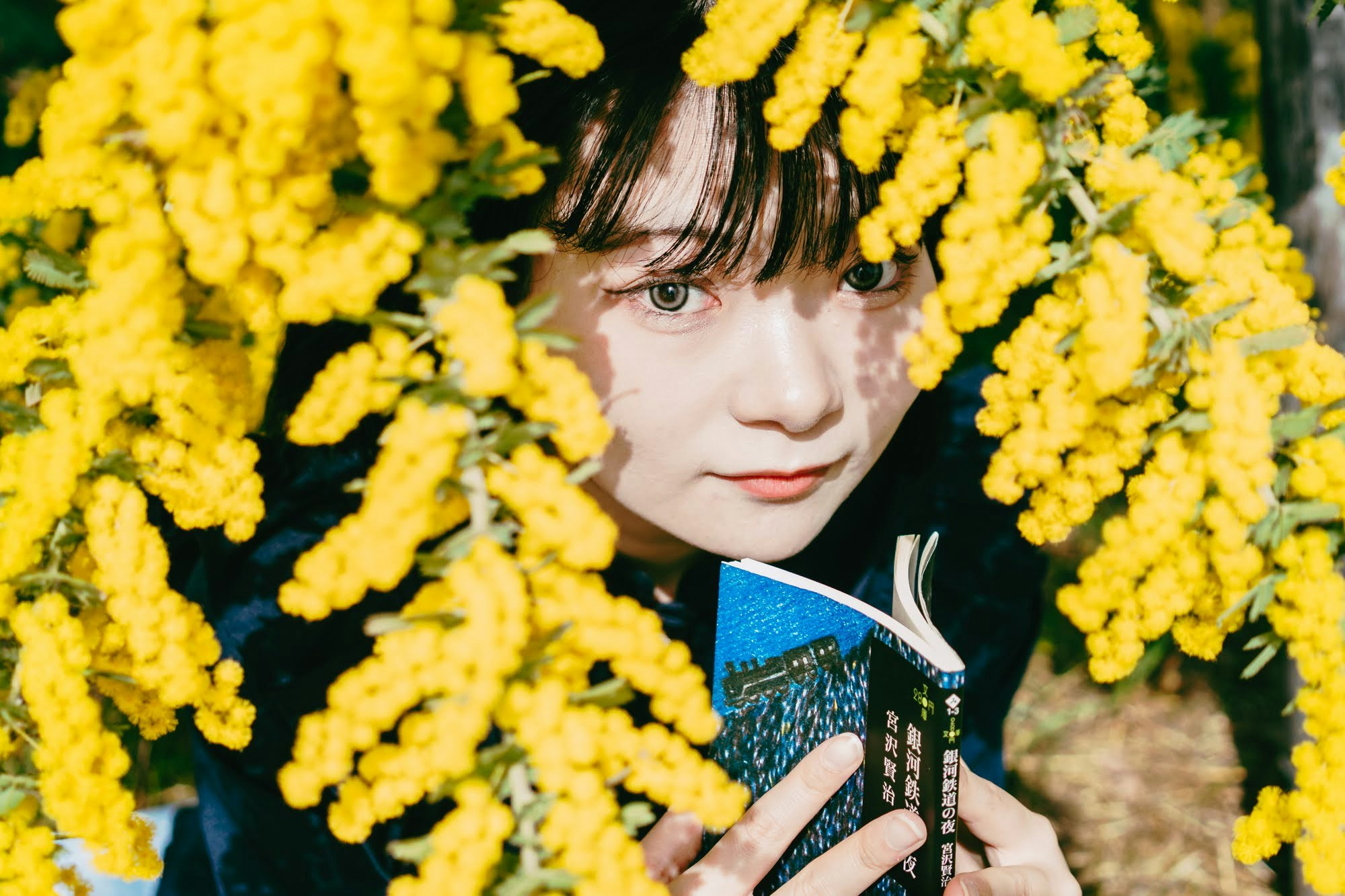 donna con una tazza circondata da fiori di mimosa