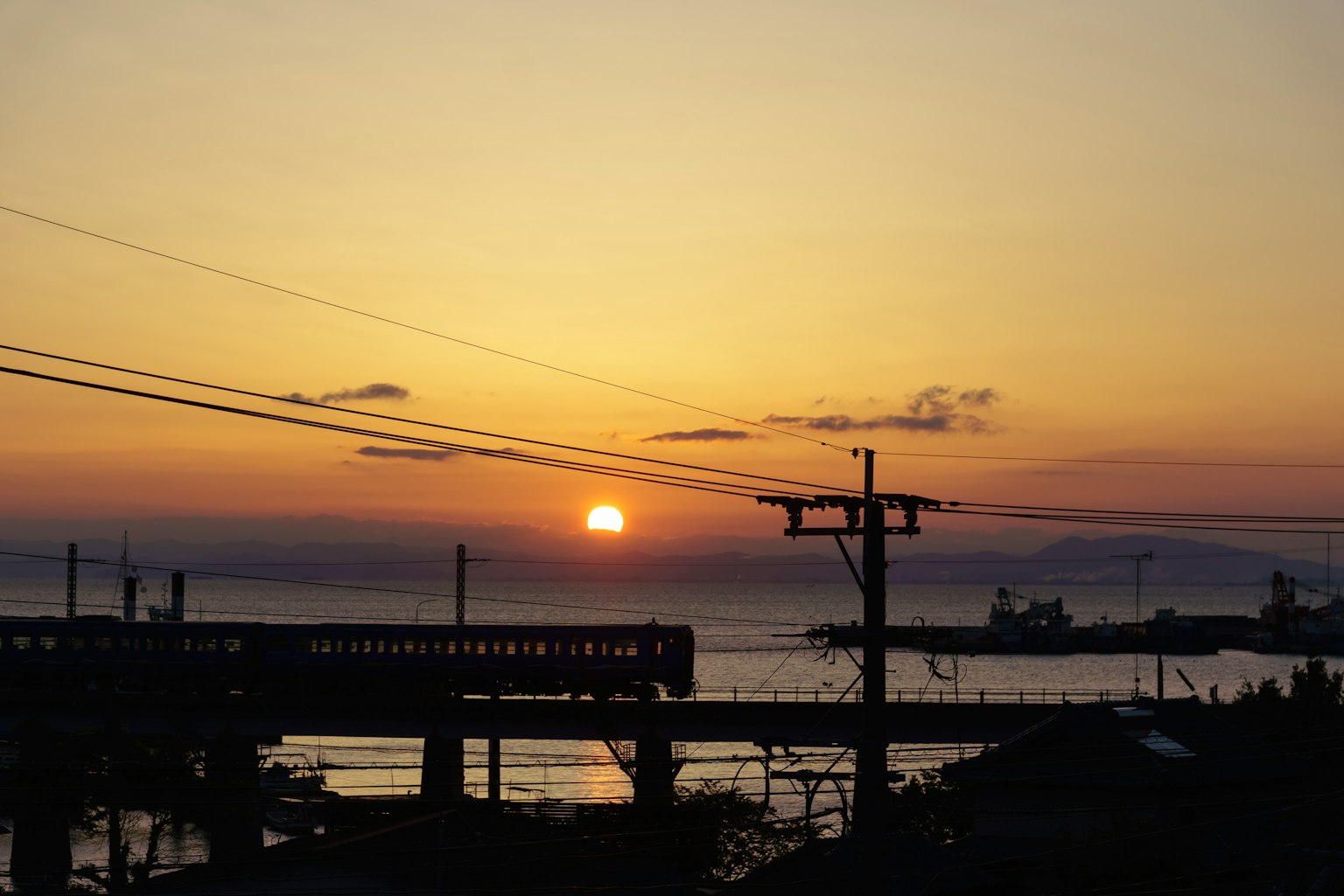 海上日落背景下的火車輪廓