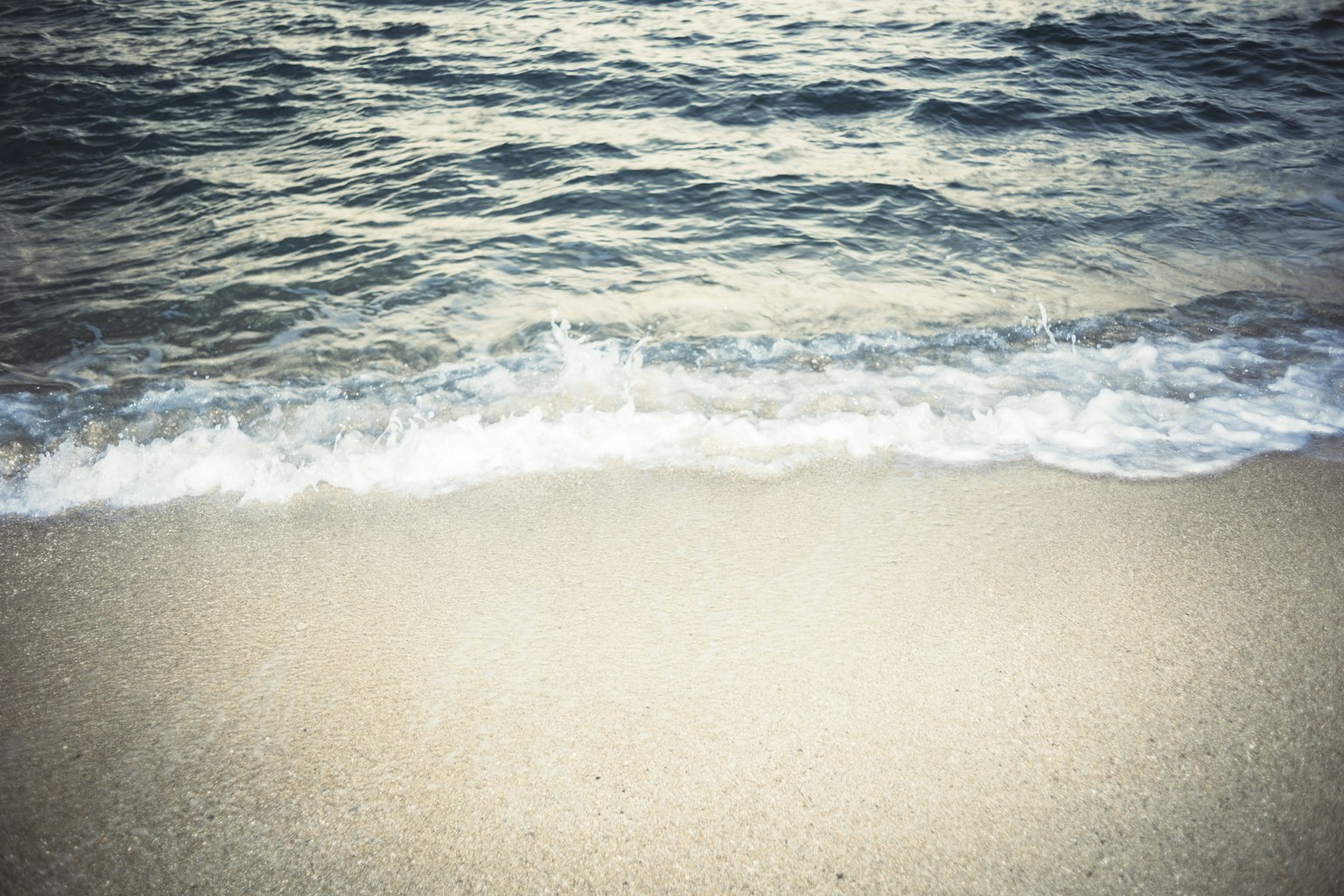 Onde gentili che si infrangono su una spiaggia sabbiosa
