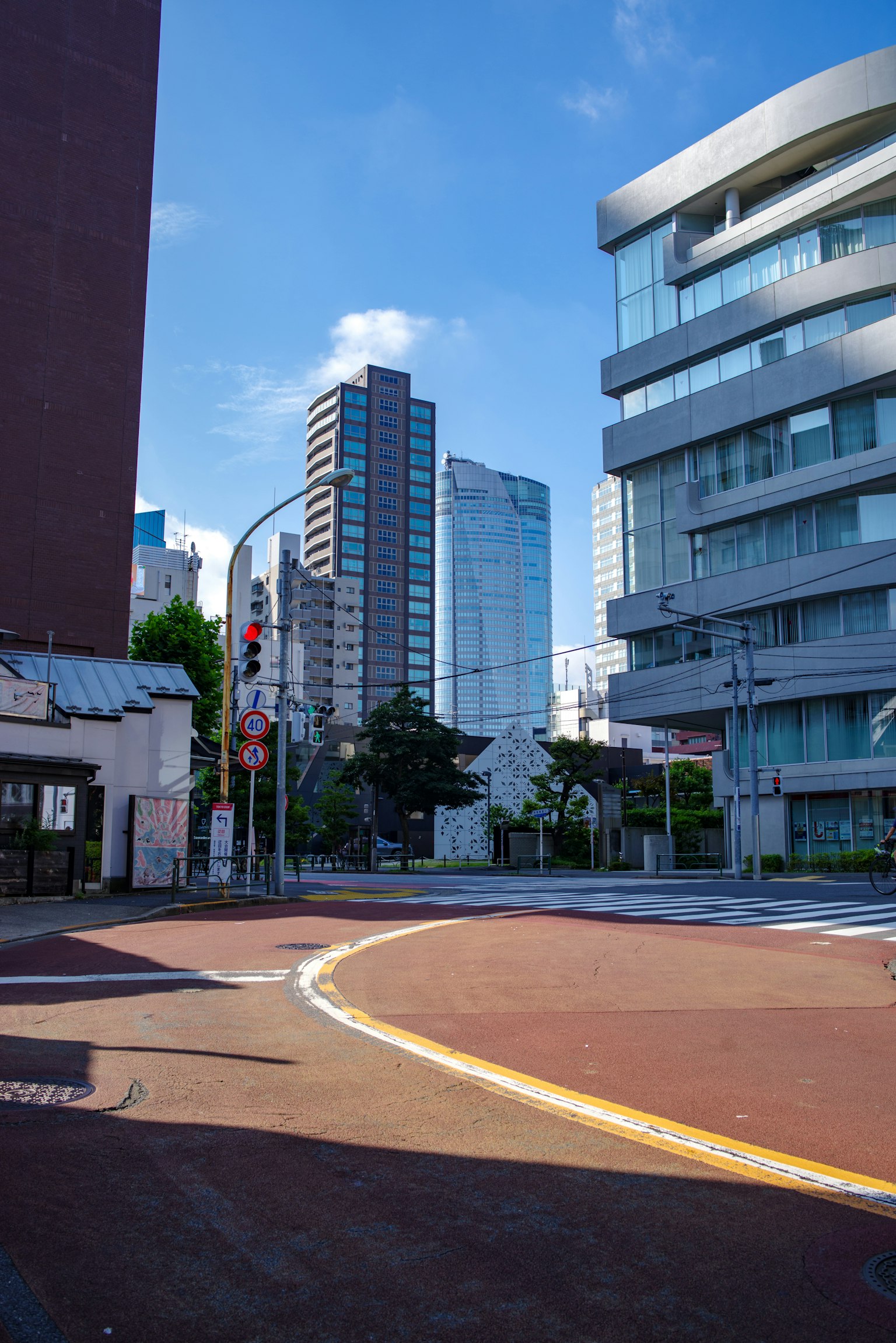 Intersection urbaine sous un ciel bleu avec des bâtiments de grande hauteur et une route courbe