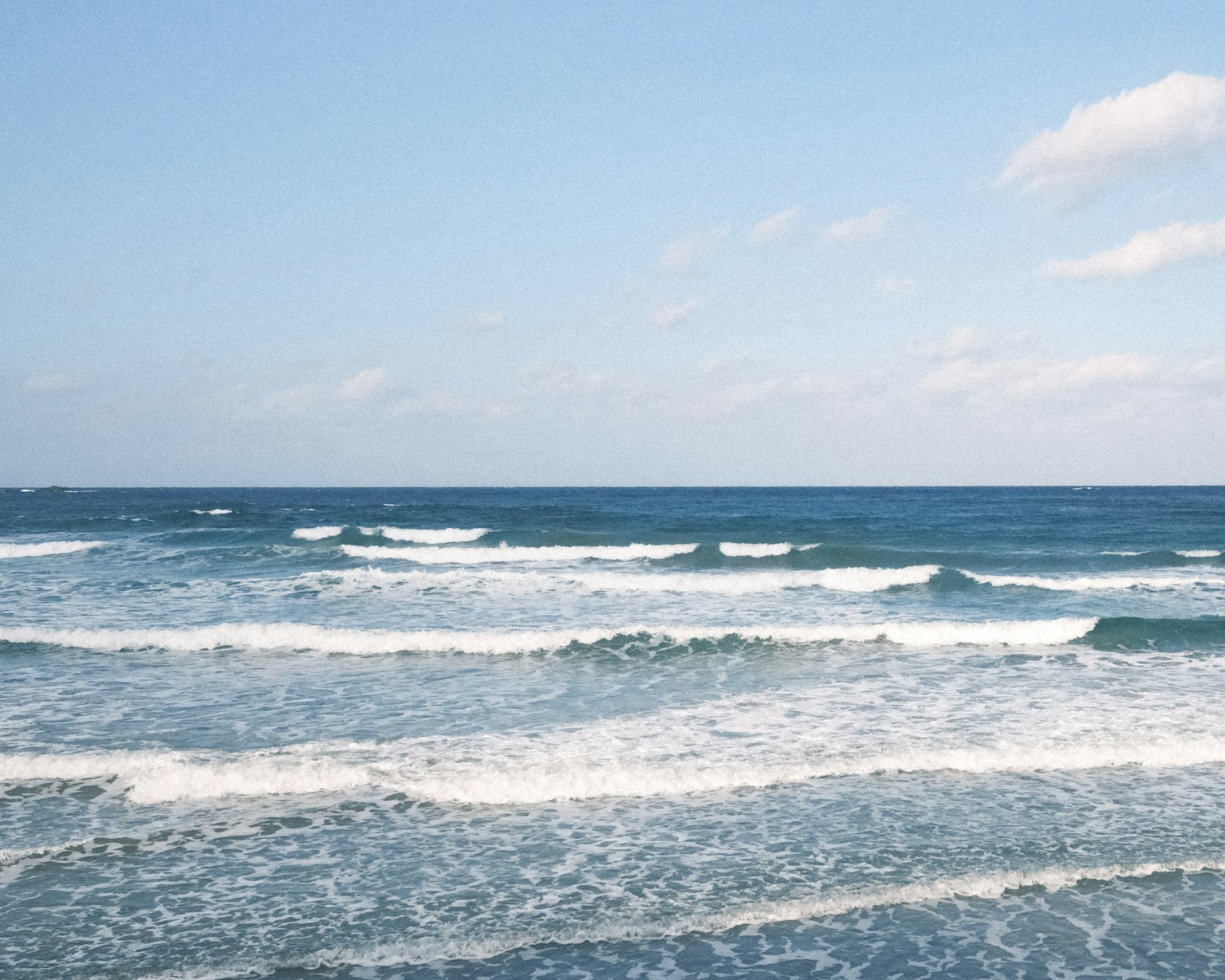 A serene view of a blue ocean with gentle waves