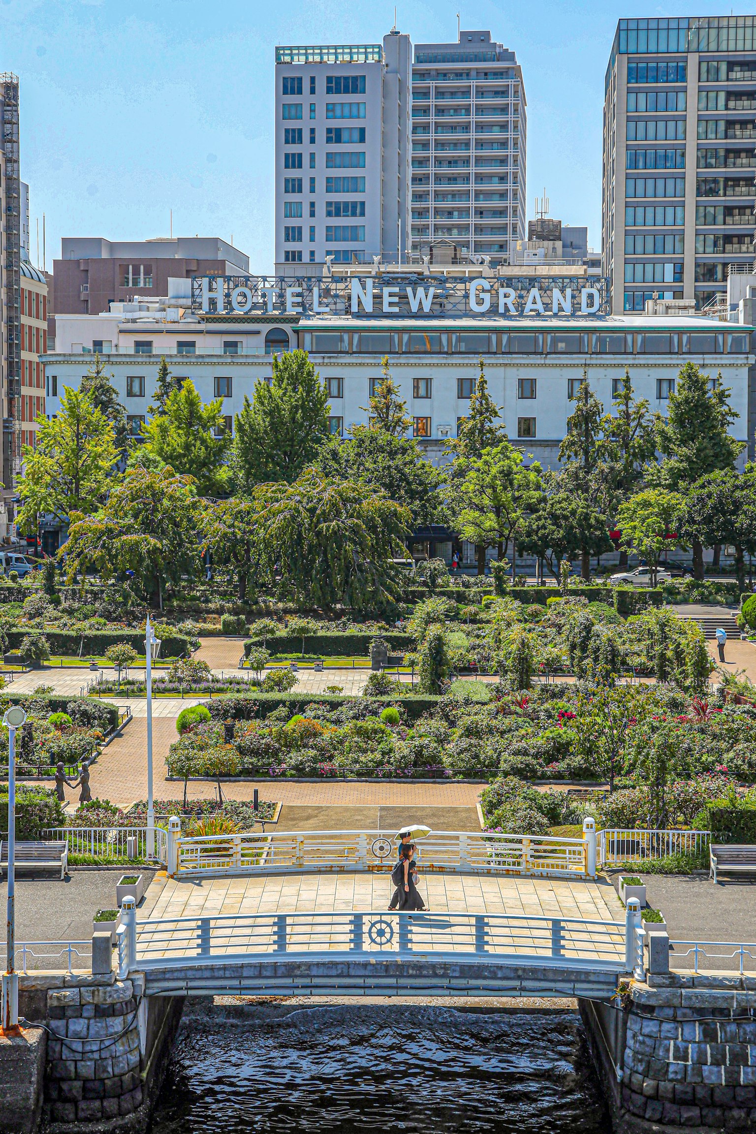 View of a park bridge with New Grand Hotel in the background