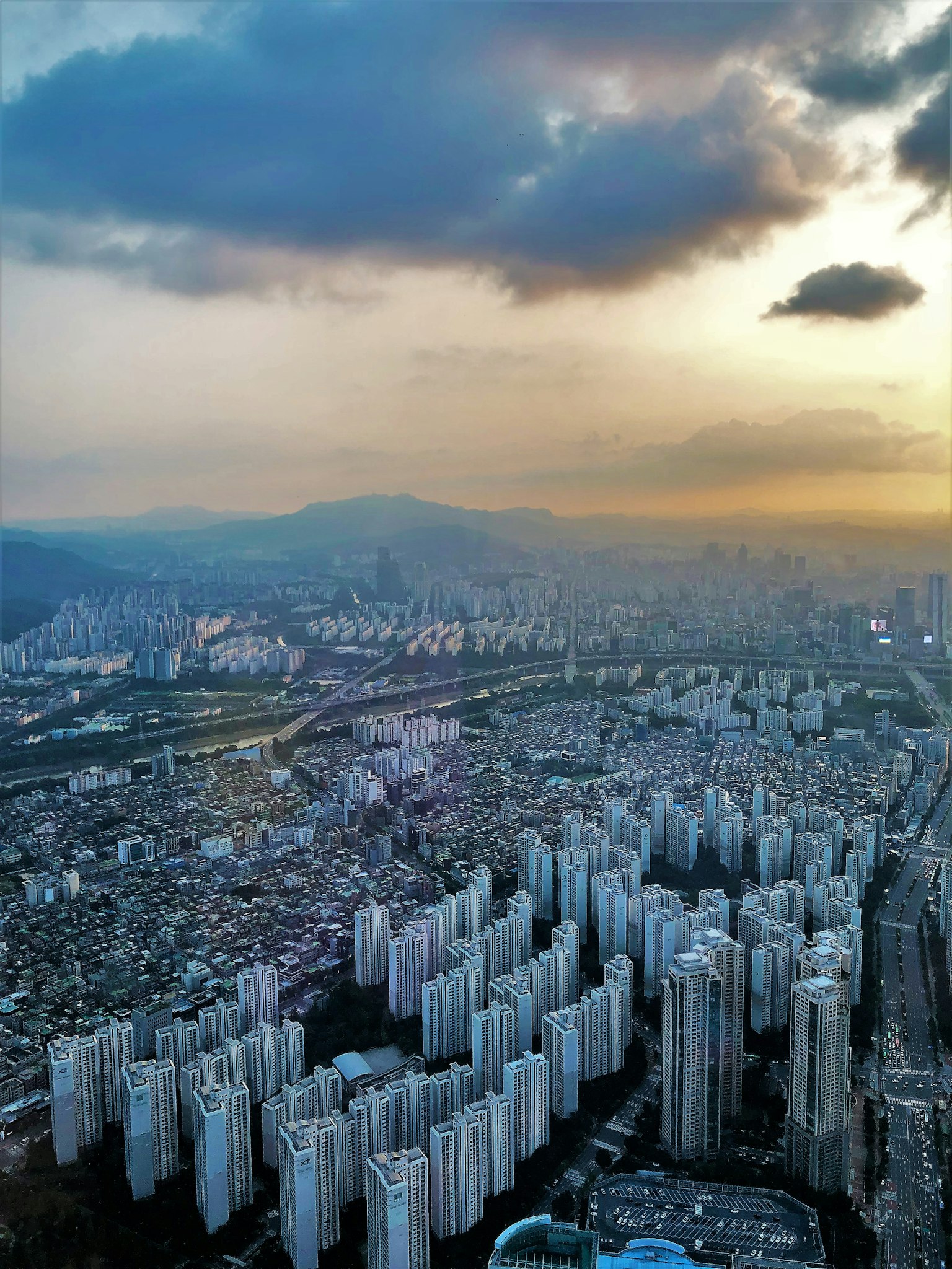Vista aérea de rascacielos y paisaje urbano en expansión al atardecer