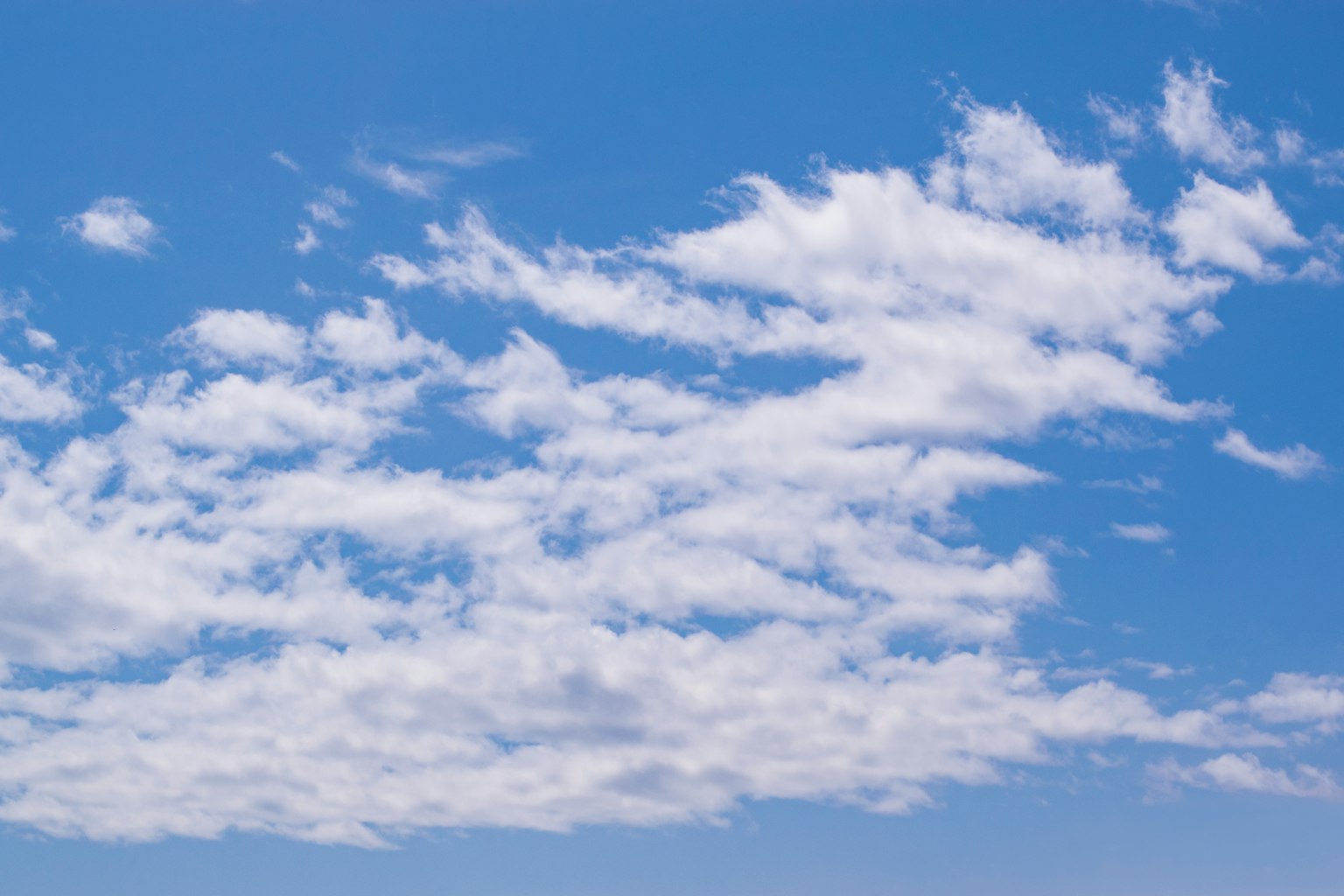 A scenic view of white clouds floating in a blue sky