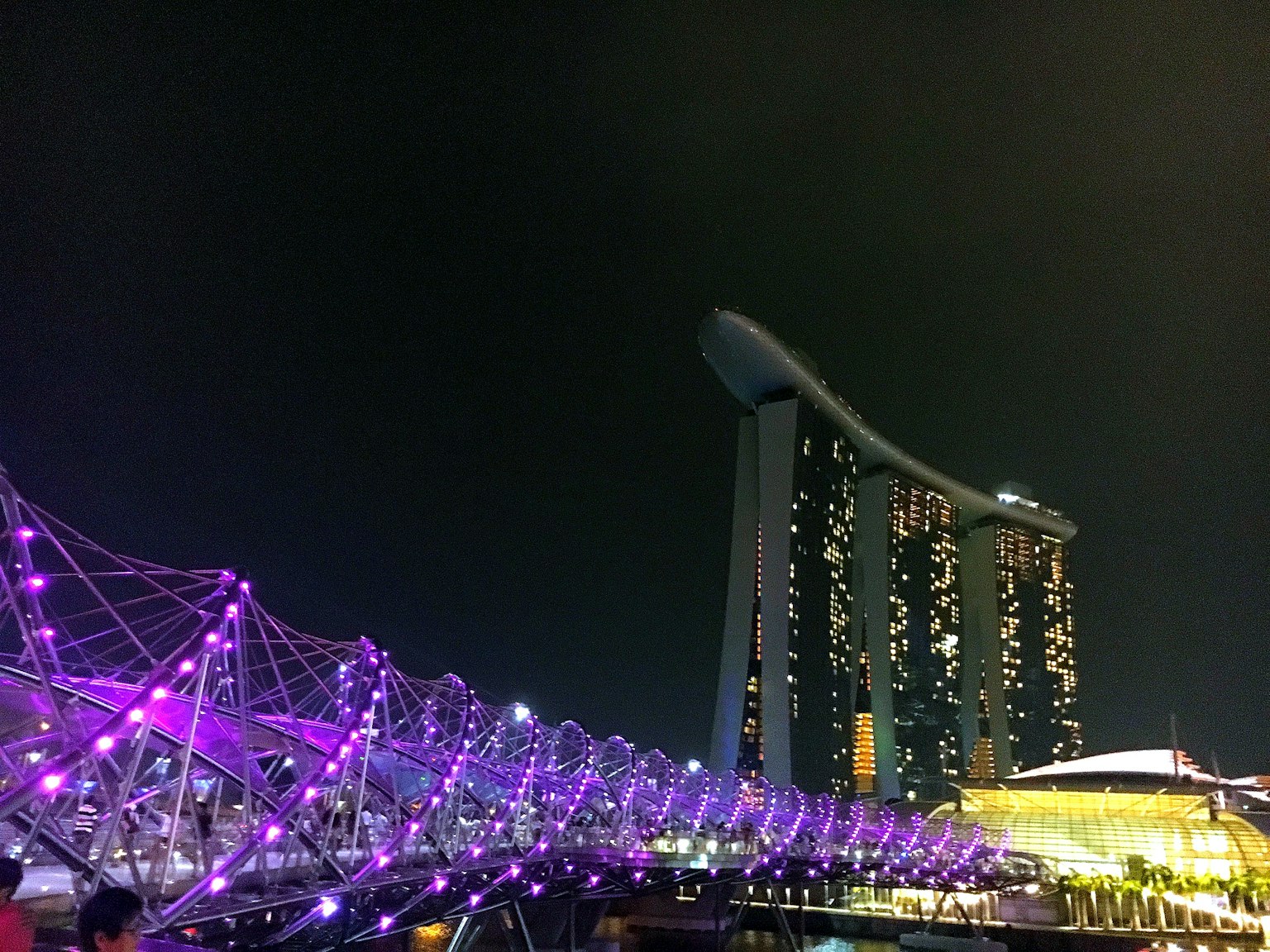 Night view of Singapore's Helix Bridge and Marina Bay Sands