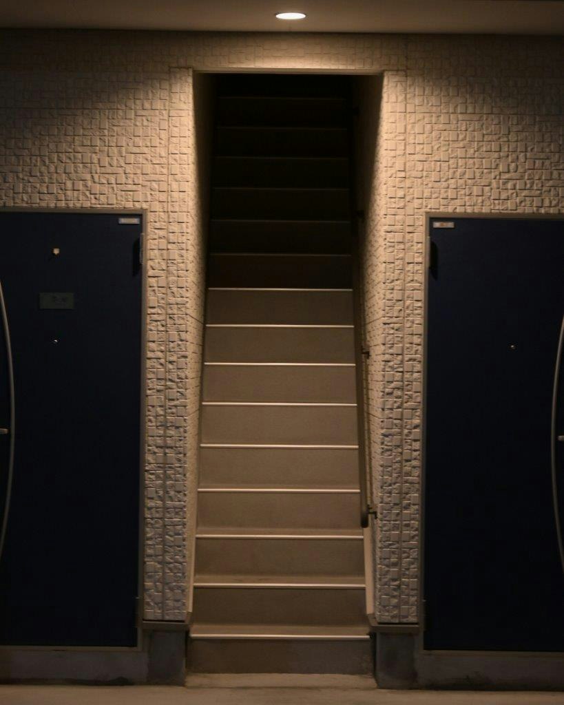 entrée avec mur en briques, arche et porte centrale, deux portes sombres