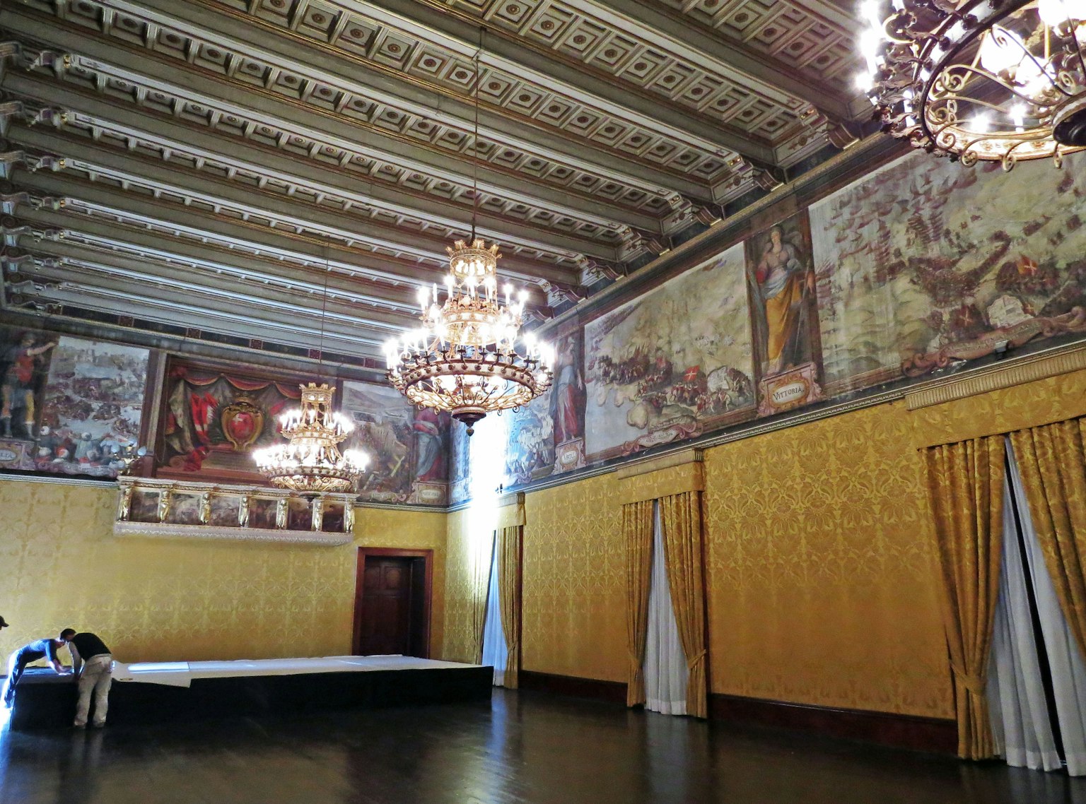 Habitación espaciosa con lujosos candelabros y hermosas pinturas murales