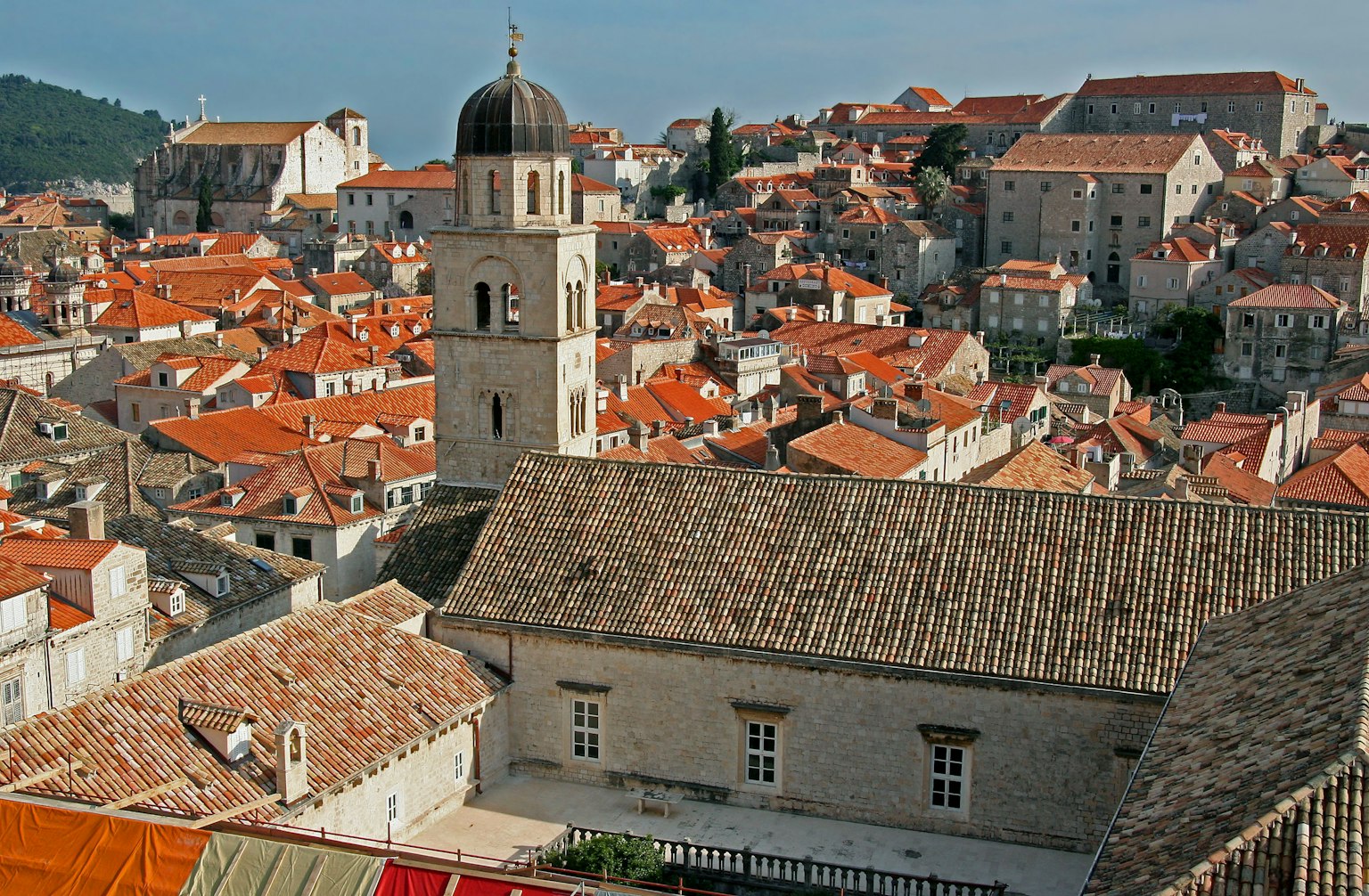 Vista panoramica di una città storica con edifici a tetto rosso e una torre di chiesa
