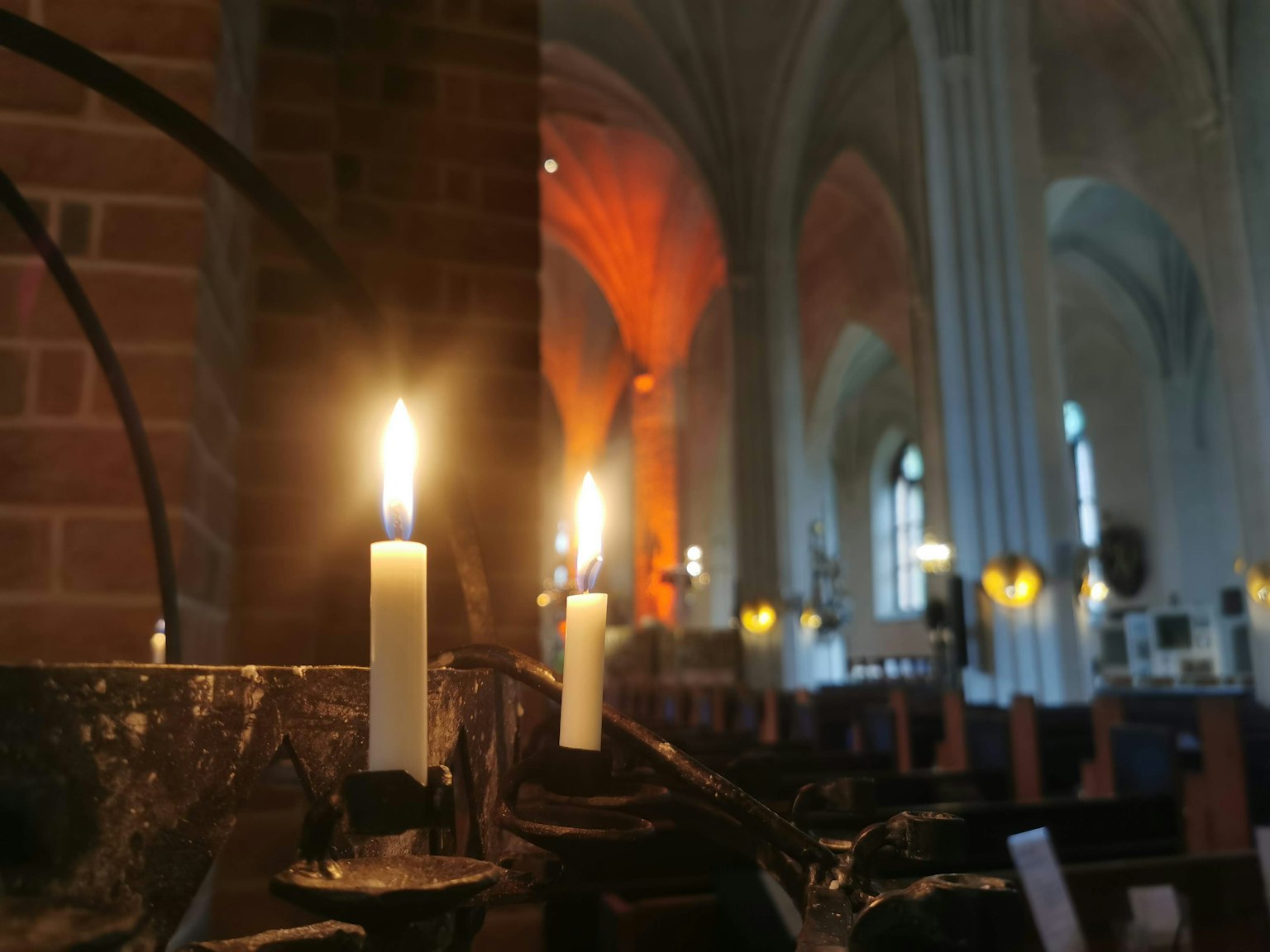 Nahaufnahme von Kerzen in einer Kirche mit hellen Flammen und sanfter Beleuchtung