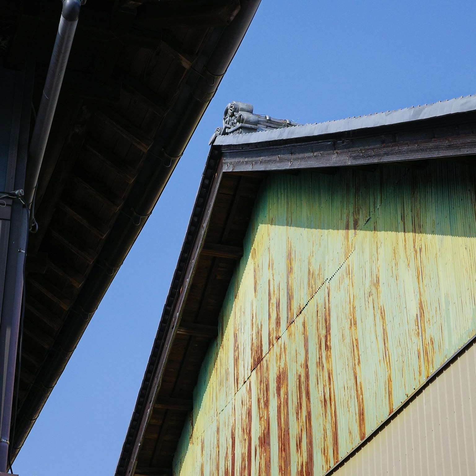 Angles et couleurs des toits d'un vieux bâtiment sous un ciel bleu