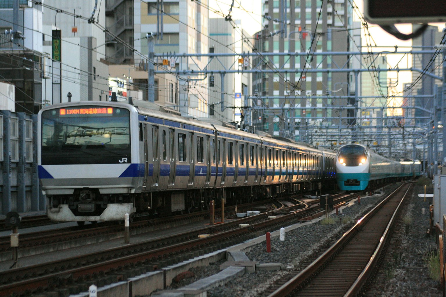 Scène ferroviaire urbaine avec des trains et des bâtiments en arrière-plan