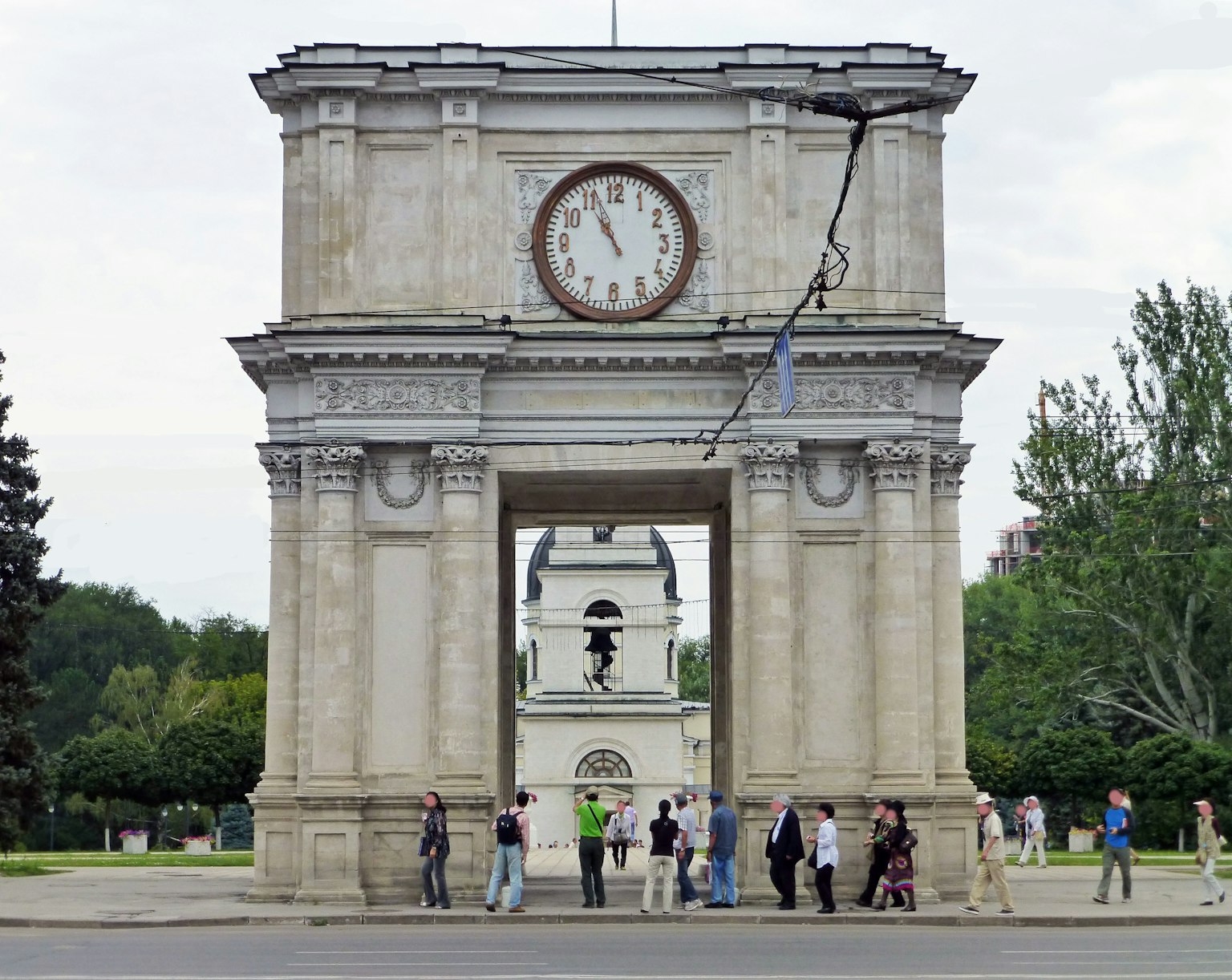 Groupe de personnes devant une arche avec une horloge